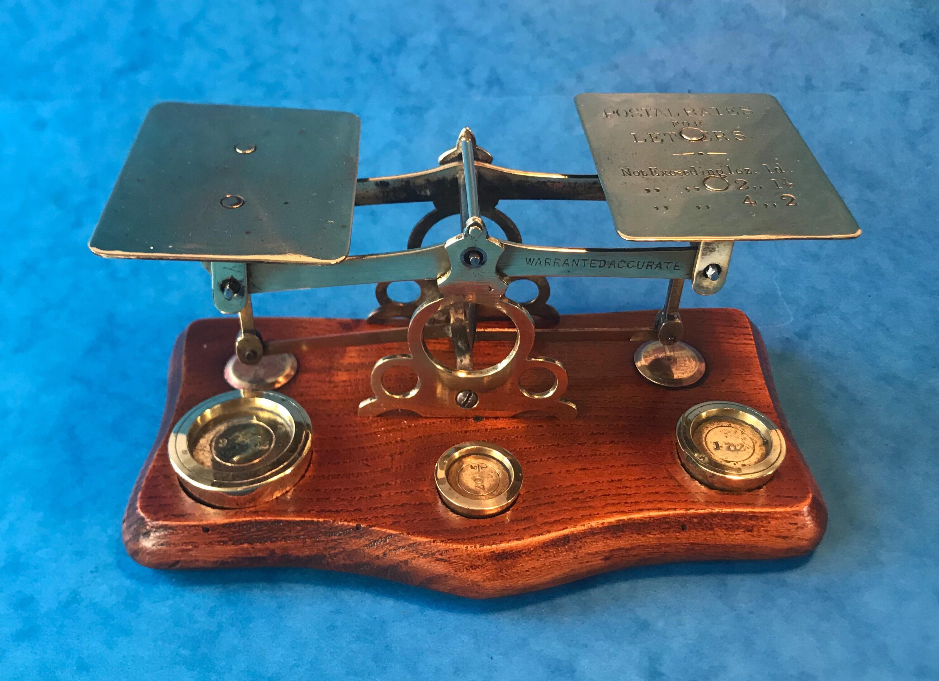 Antique Victorian brass letter scales, the letter scales date back to 1870 and sit on an oak base. They are in lovely original condition with three original weights, with the original postage rates to the scale. They measure 16.5 by 10 and stands
