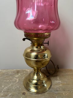 Victorian brass oil lamp with a cranberry glass shade, 1910