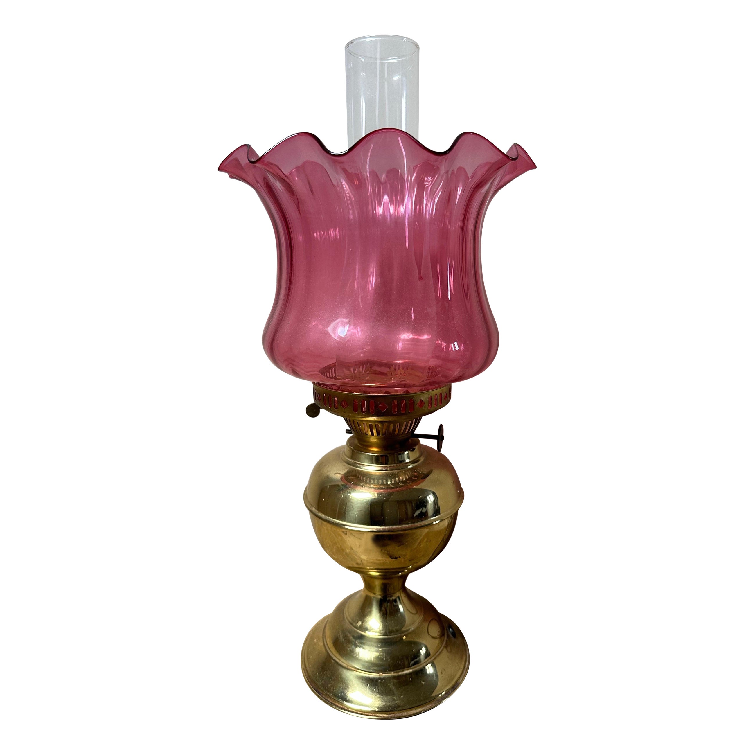 Victorian brass oil lamp with a cranberry glass shade, 1910 For Sale