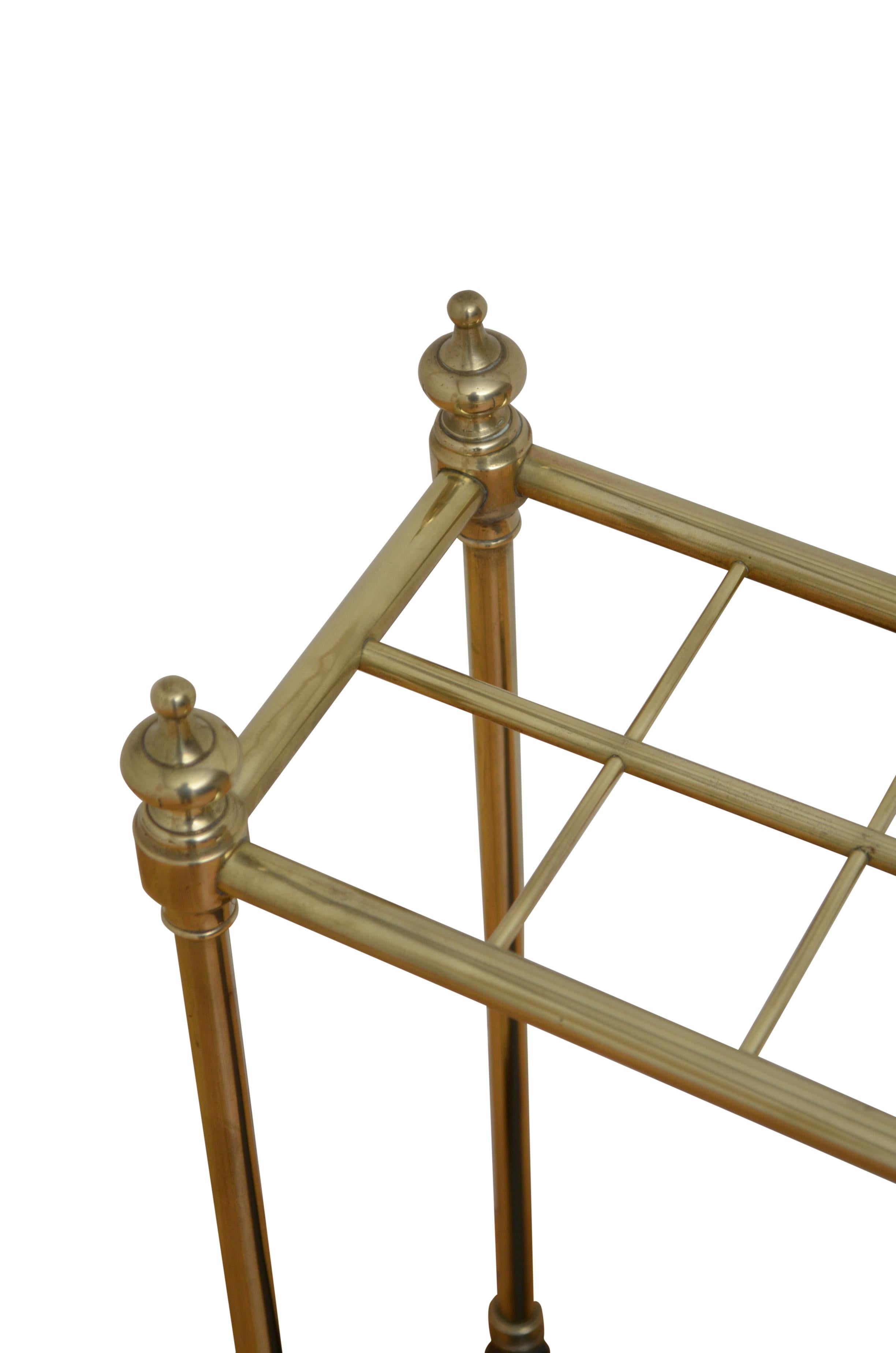 K0556 Victorian umbrella stand in brass having twelve umbrella or walking sticks divisions flanked by finials and cast iron drip tray with dog tooth decoration. This antique umbrella stand has been cleaned and polished and is ready to place at home.