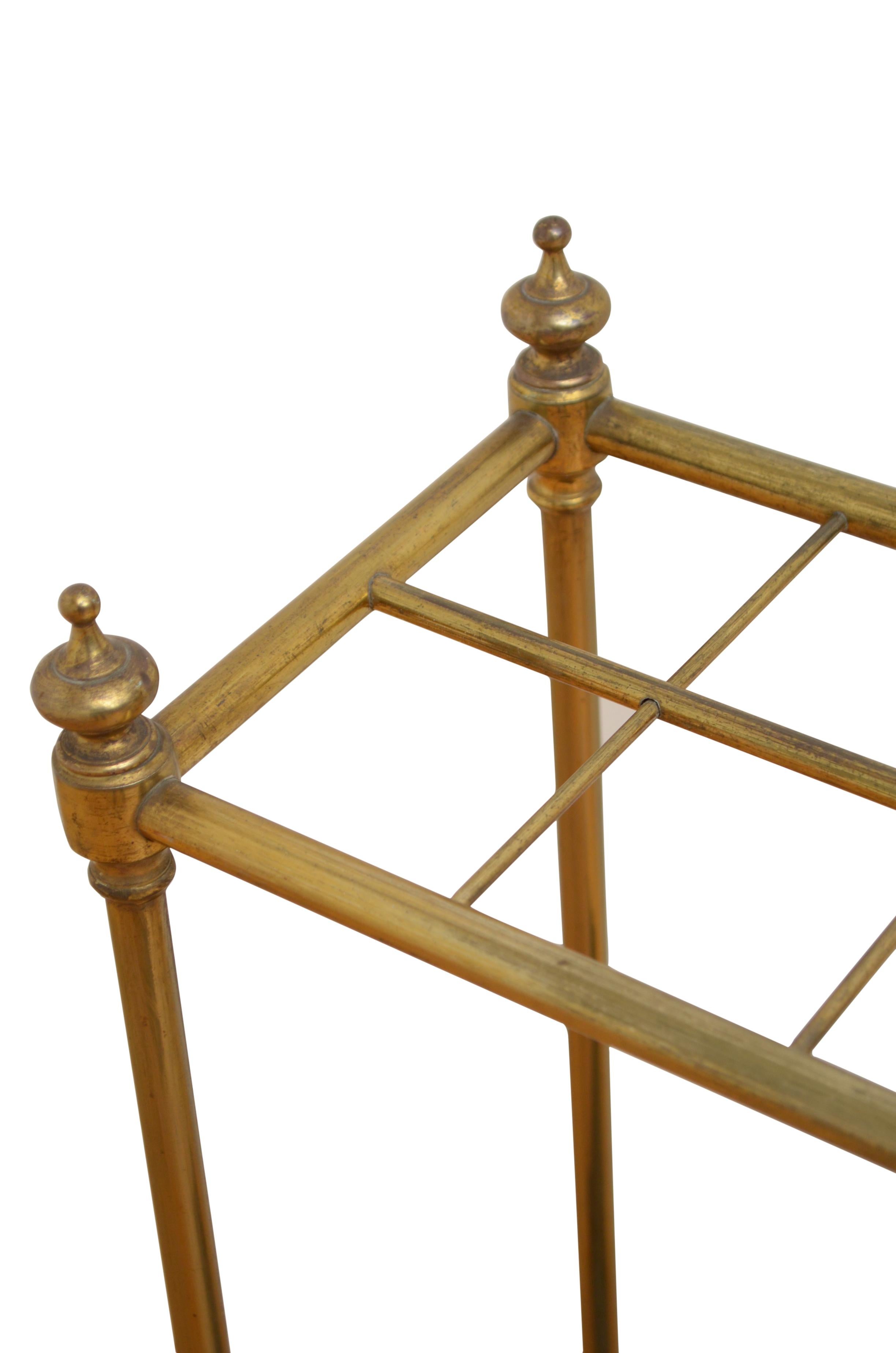 0229 Victorian umbrella stand in brass, having eight umbrella and walking sticks divisions, decorative finials and removable drip tray to cast iron base. This antique umbrella stand retains its original patina, all in home ready condition, circa