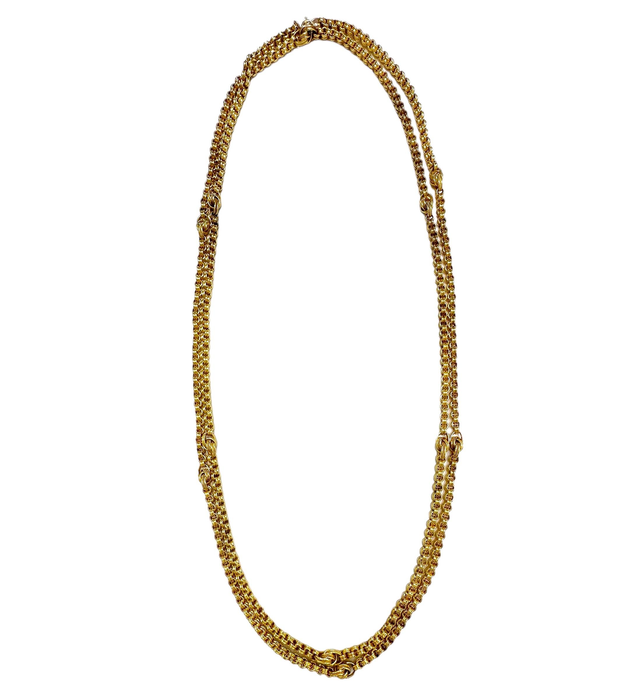 This interesting 55 inch long 15k yellow gold Victorian period British necklace is comprised of a single line of double spiral links punctuated by knot motif links at 4 1/4 inch intervals. The knot links are larger double spiral links edged with