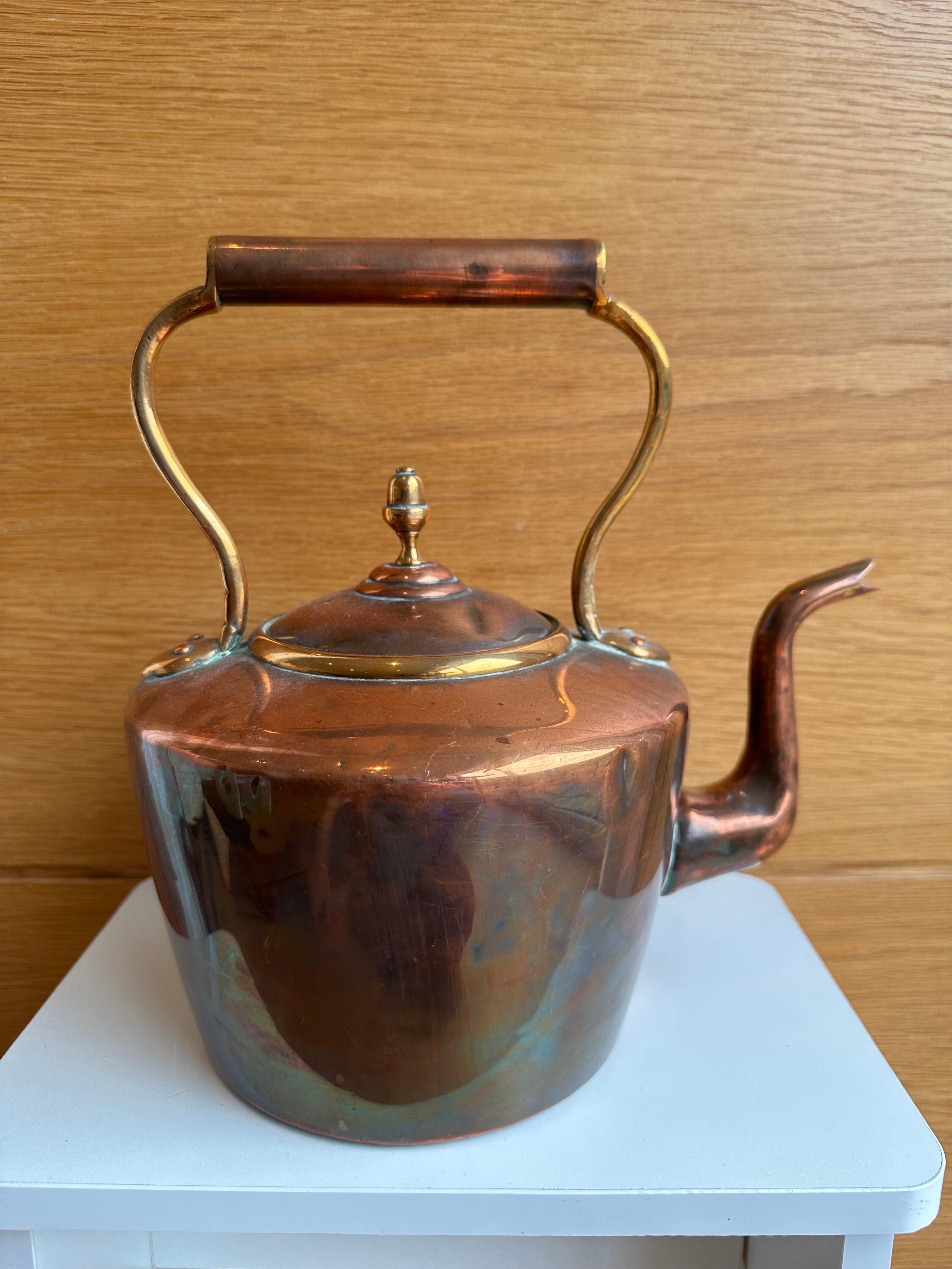 A beautiful copper plated brass kettle with bronze lid. The kettle lifts with a copper handle with a bronze handhold. Some copper patina and wear revealing brass can be seen at the joins. Perfect for decoration or home use.