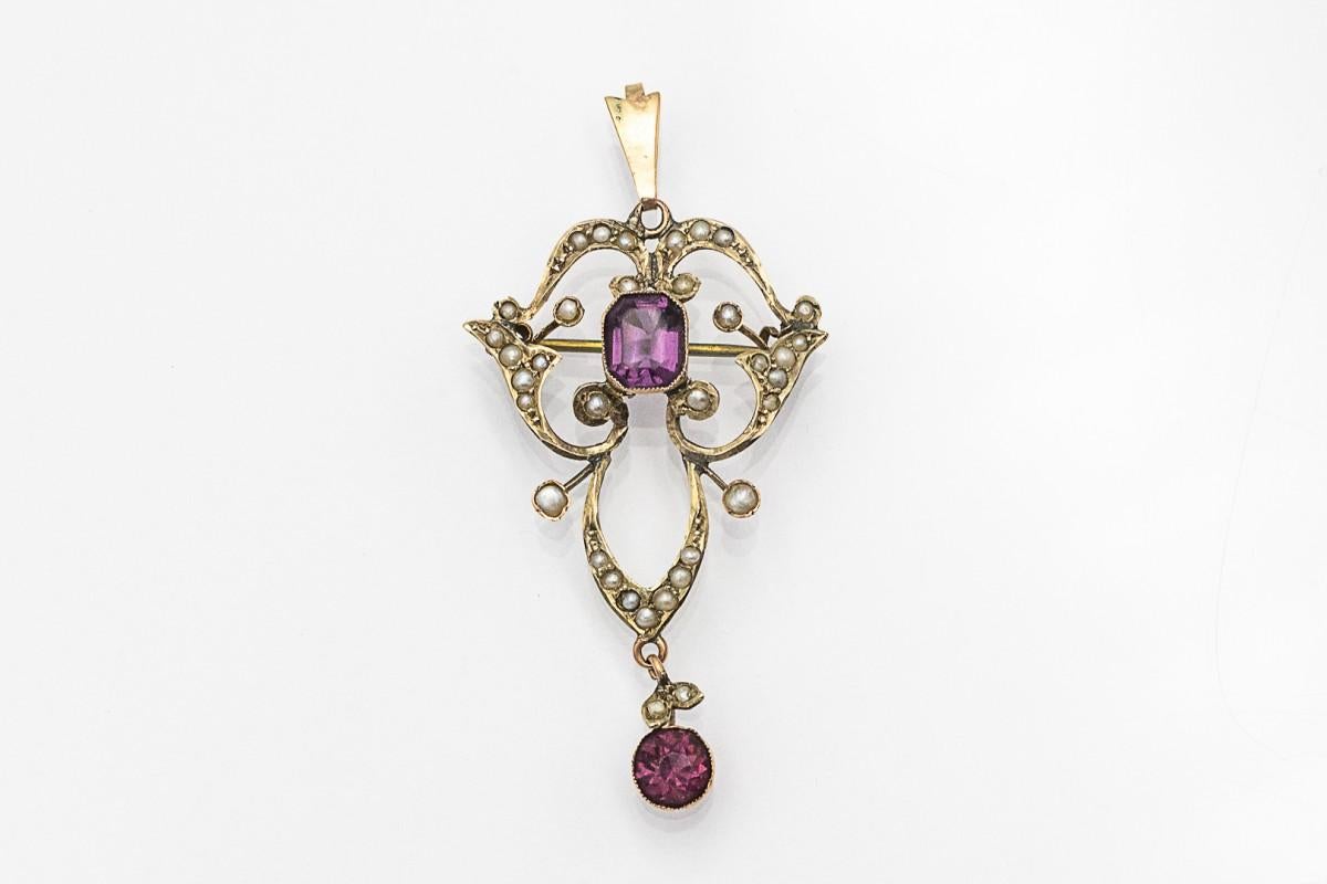 Pendant/brooch in the Art Nouveau style, 
made of 9-karat yellow gold (0.375 fineness) and silver elements. 
Art Nouveau brooch pendant decorated with faceted amethysts and pearls.

Origin: England, circa 1900.

Dimensions: 52 x 28 mm,

Condition: