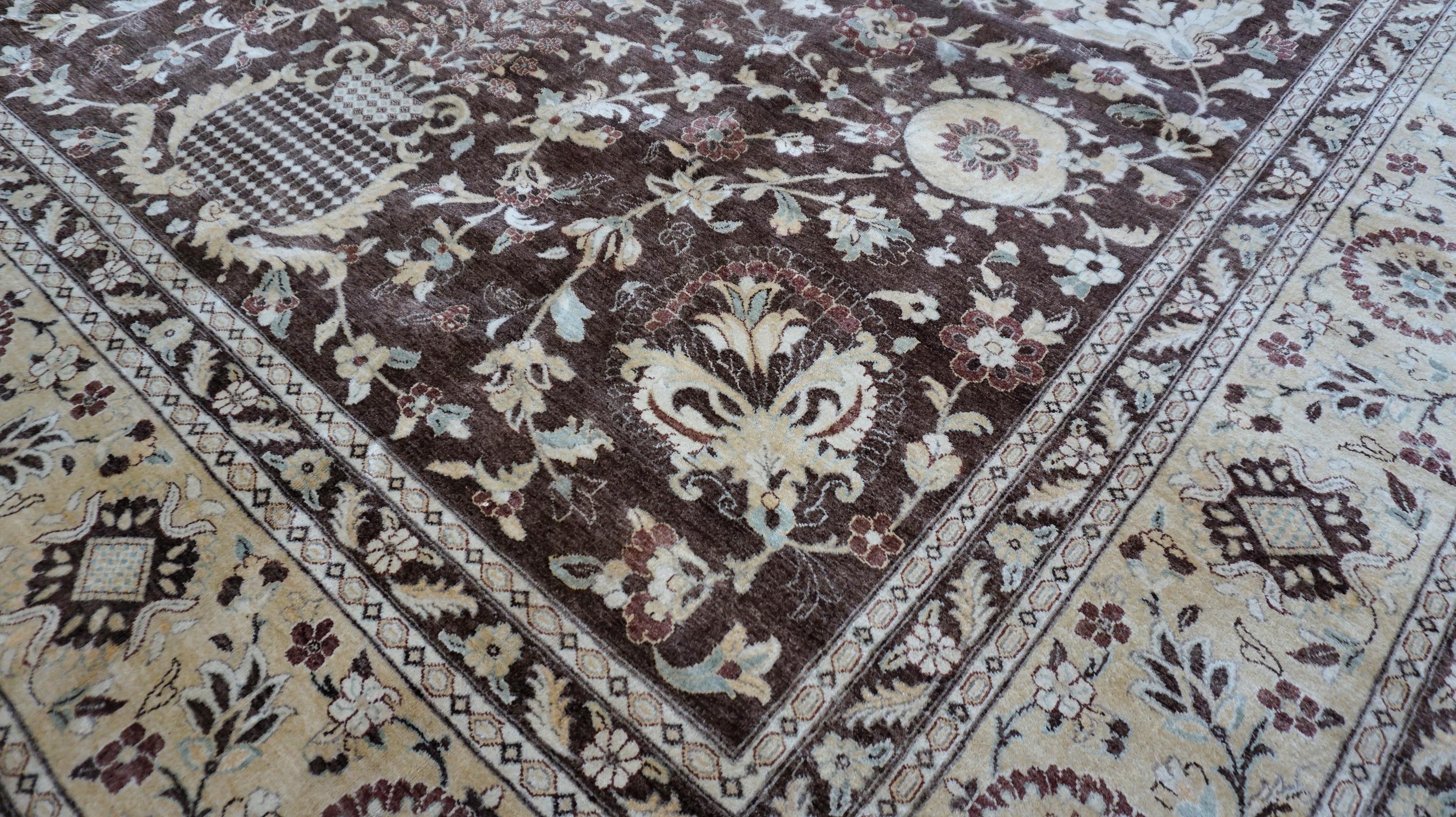 Questo tappeto in lana annodato a mano presenta un intramontabile disegno a medaglione floreale, reso in un lussuoso campo marrone espresso accentuato da bordi avorio e marrone tenue. Meticolosamente intrecciato da abili artigiani, questo pezzo