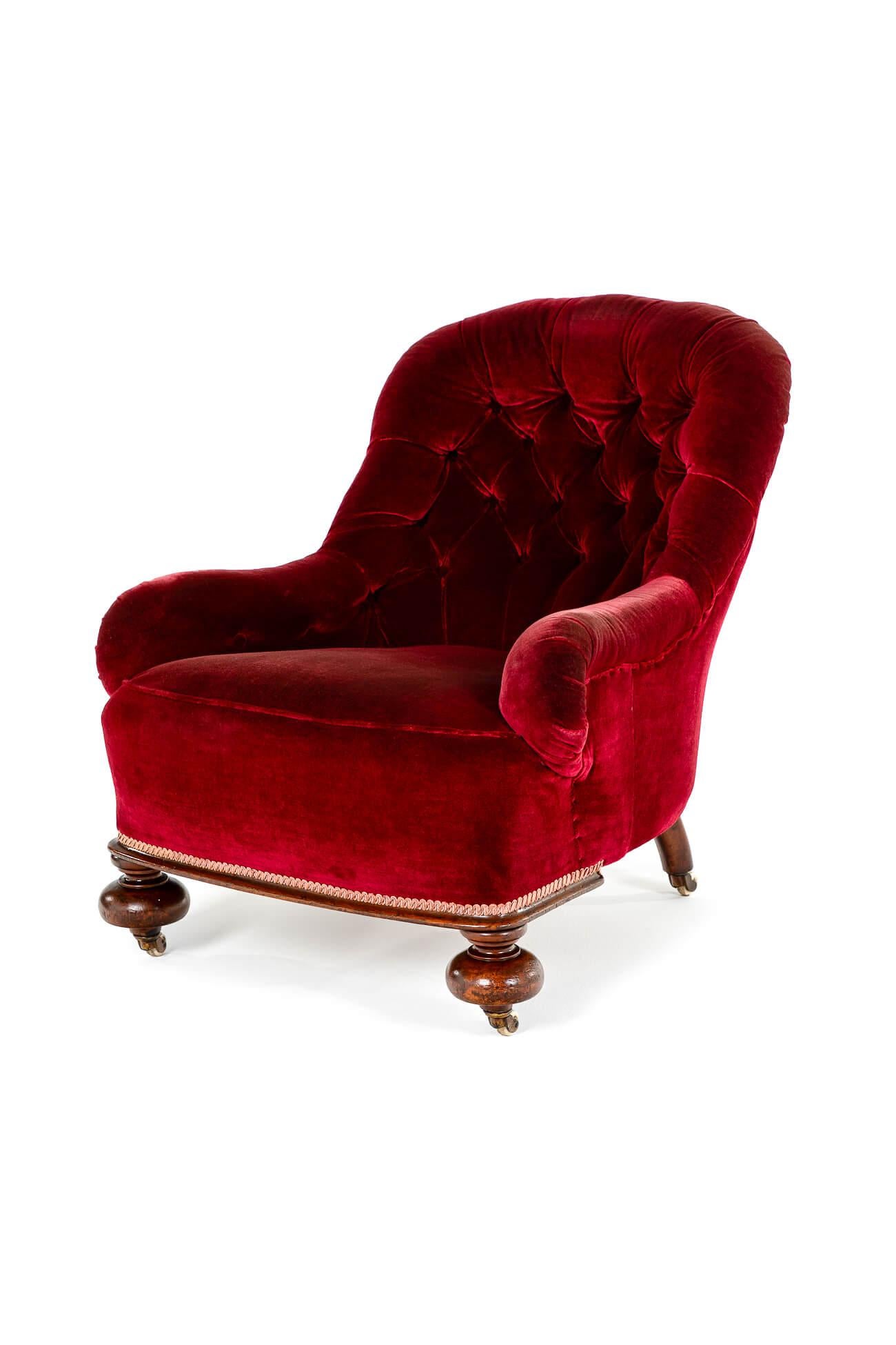 A wide Victorian deep button-back armchair with turned legs, raised on castors.

The armchair is in its original burgundy-coloured velvet upholstery and is in excellent condition for its age.

The mahogany frame has peg joints and the back and arms