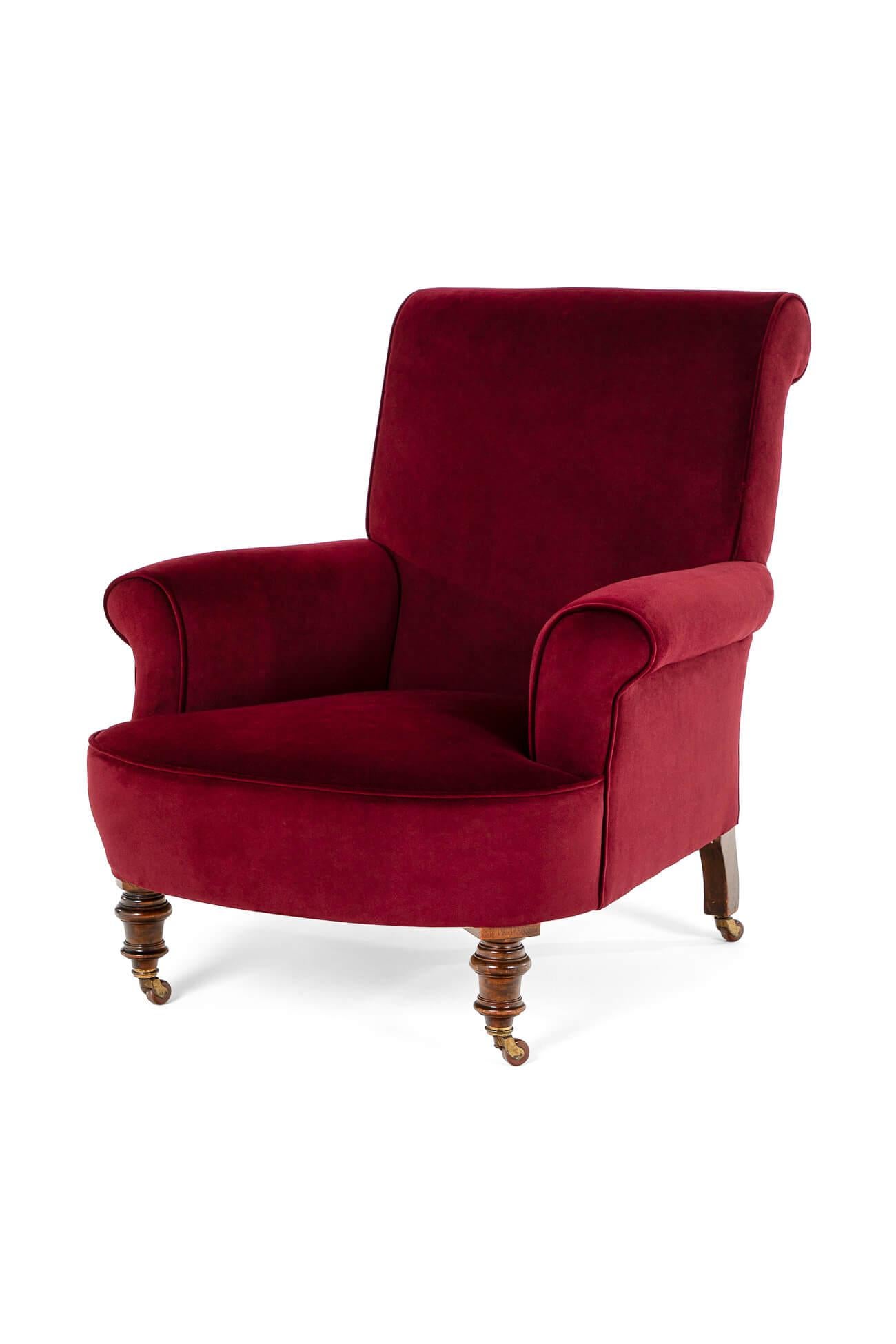 A burgundy velvet armchair of generous proportions.

High back with a deep seat and scrolling arms and back.

Mahogany frame with turned front legs raised on original castors.

Fully reupholstered with hessian and calico to the walnut frame,
