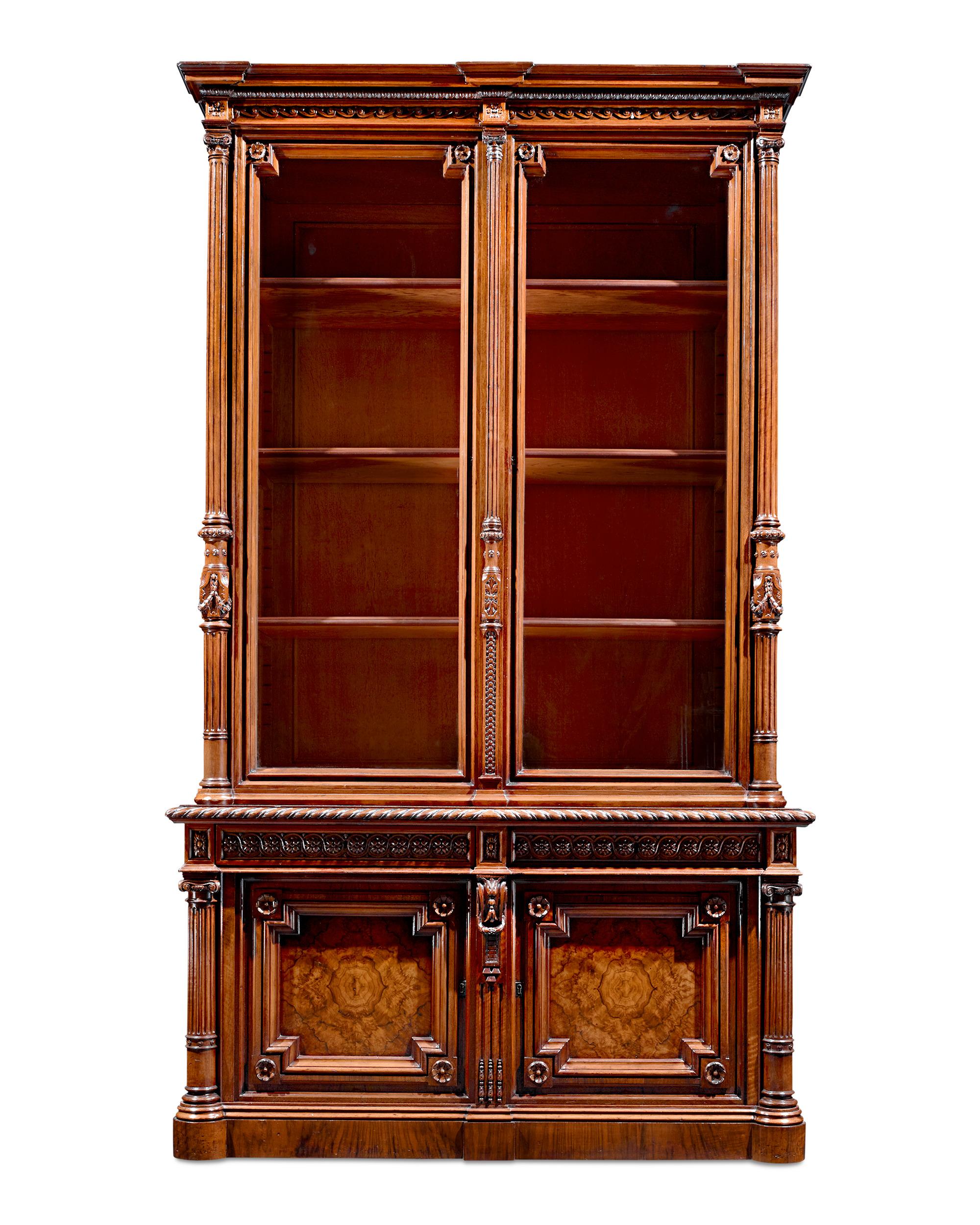 Carving of the highest caliber adorns the façade of this exceptional Victorian-era bookcase. Constructed entirely of rare burl walnut, this case is adorned with impeccably designed carvings, from majestic scrolls and neoclassical columns to charming