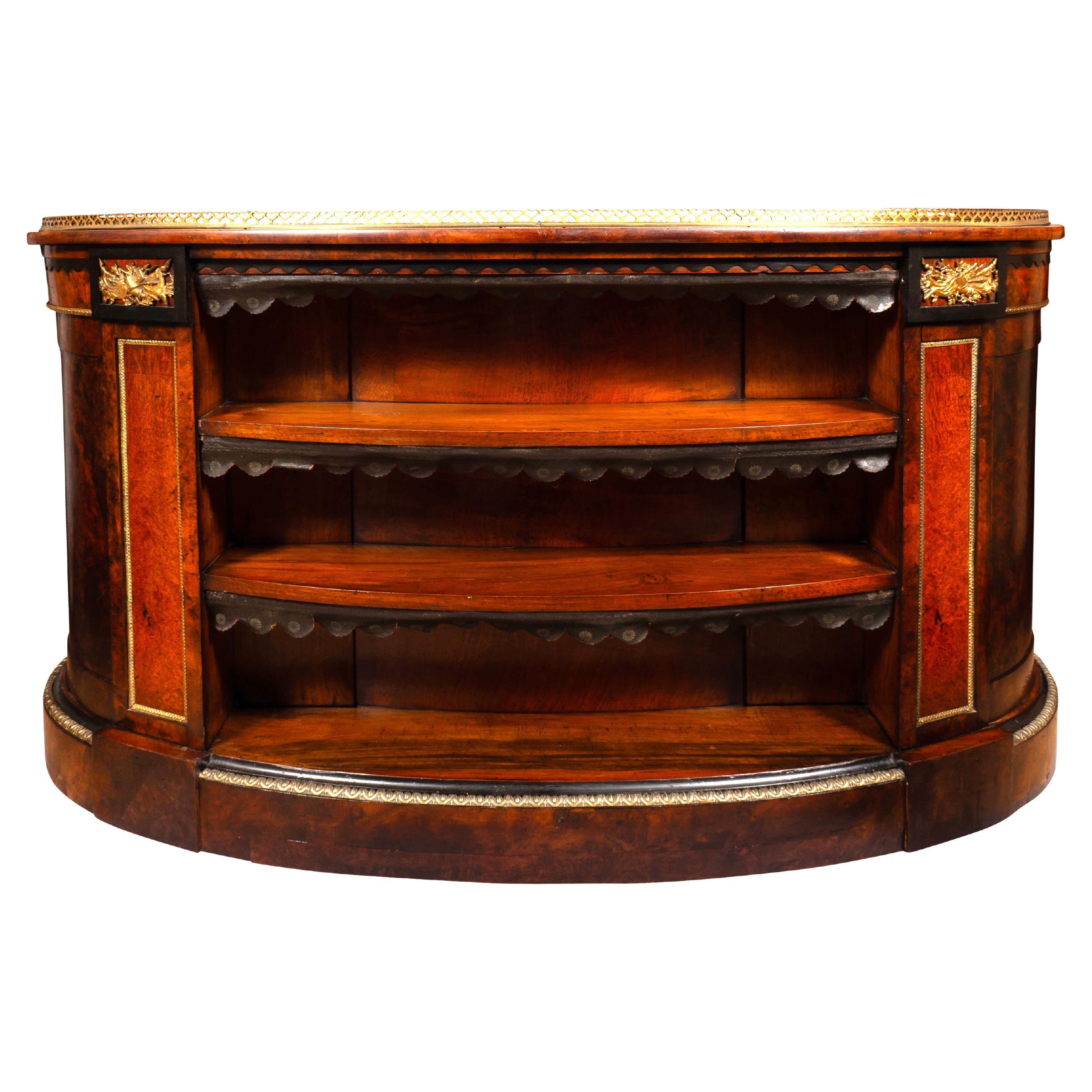 Kidney shaped top with conforming inset green leather and brass gallery over a central drawer flanked by smaller drawers and three drawers on each side of the knee hole. The reverse finished and having shelving. Bronze knobs and trim and military