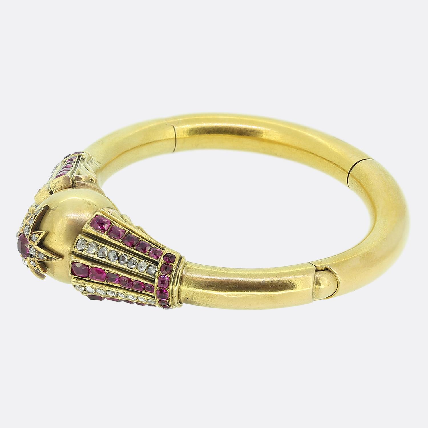 Here we have an outstanding bangle taken from the Victorian era. This rich 18ct yellow gold piece boasts a unique design with a spherical face playing host to an eight-pointed star motif set with a round faceted pink Burmese ruby at the centre and