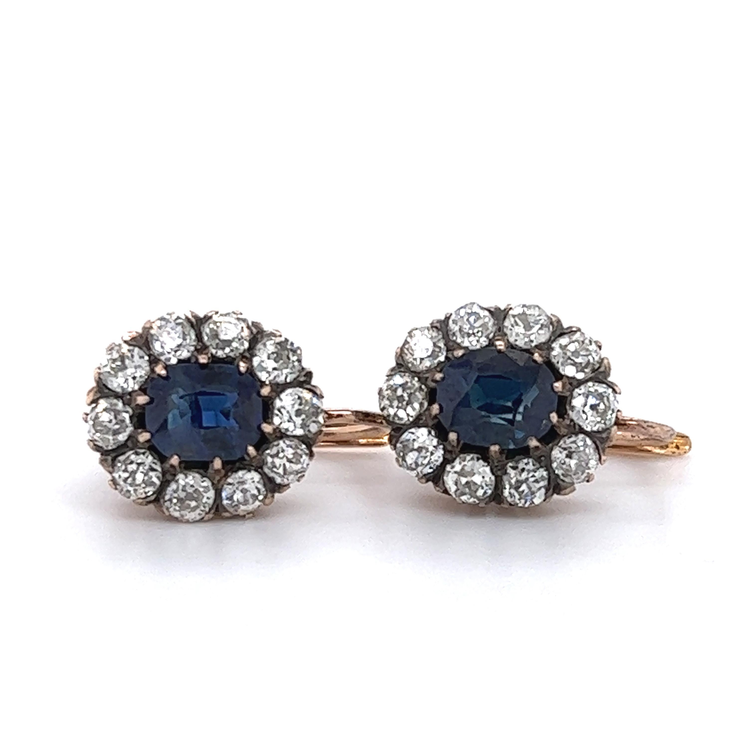 Beautiful design seen on these hand crafted sapphire and diamond dangling earrings. The earrings are crafted in 18k yellow gold and truly stand out as a Victorian classic. The earrings highlight two burmese sapphires. The sapphire's displays a rich