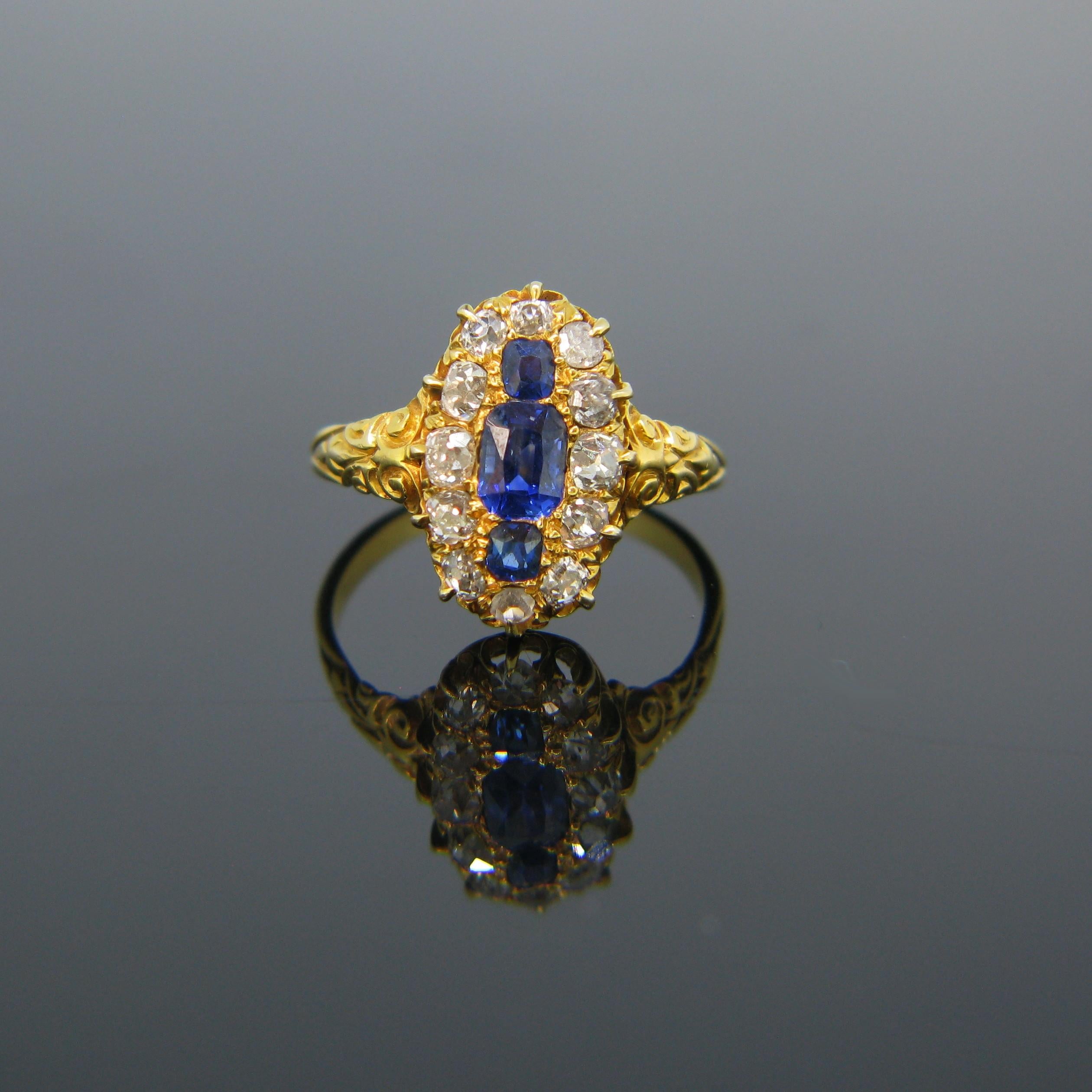 This beautiful marquise ring from the Victorian era is fully made in 18kt yellow gold. In the centre, it is with 3 rectangular cushion sapphires of Burmese origin and no indications of heating. They have a very vibrant royal blue colour. They are