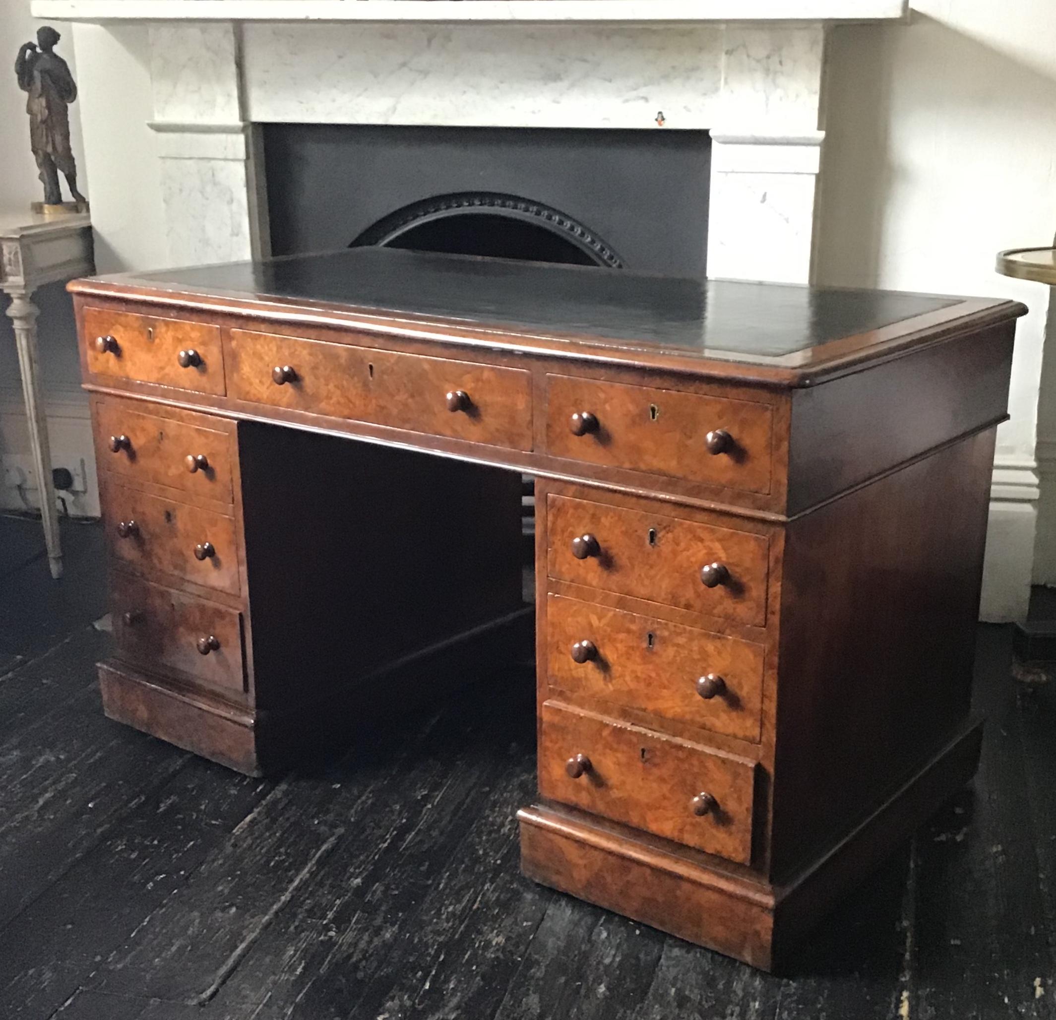 A Victorian burr walnut twin pedestal desk with hand tooled black leather writing surface above three frieze drawers and three further graduated drawers to each pedestal .The right hand frieze drawer being stamped with the makers name “T Crunden and