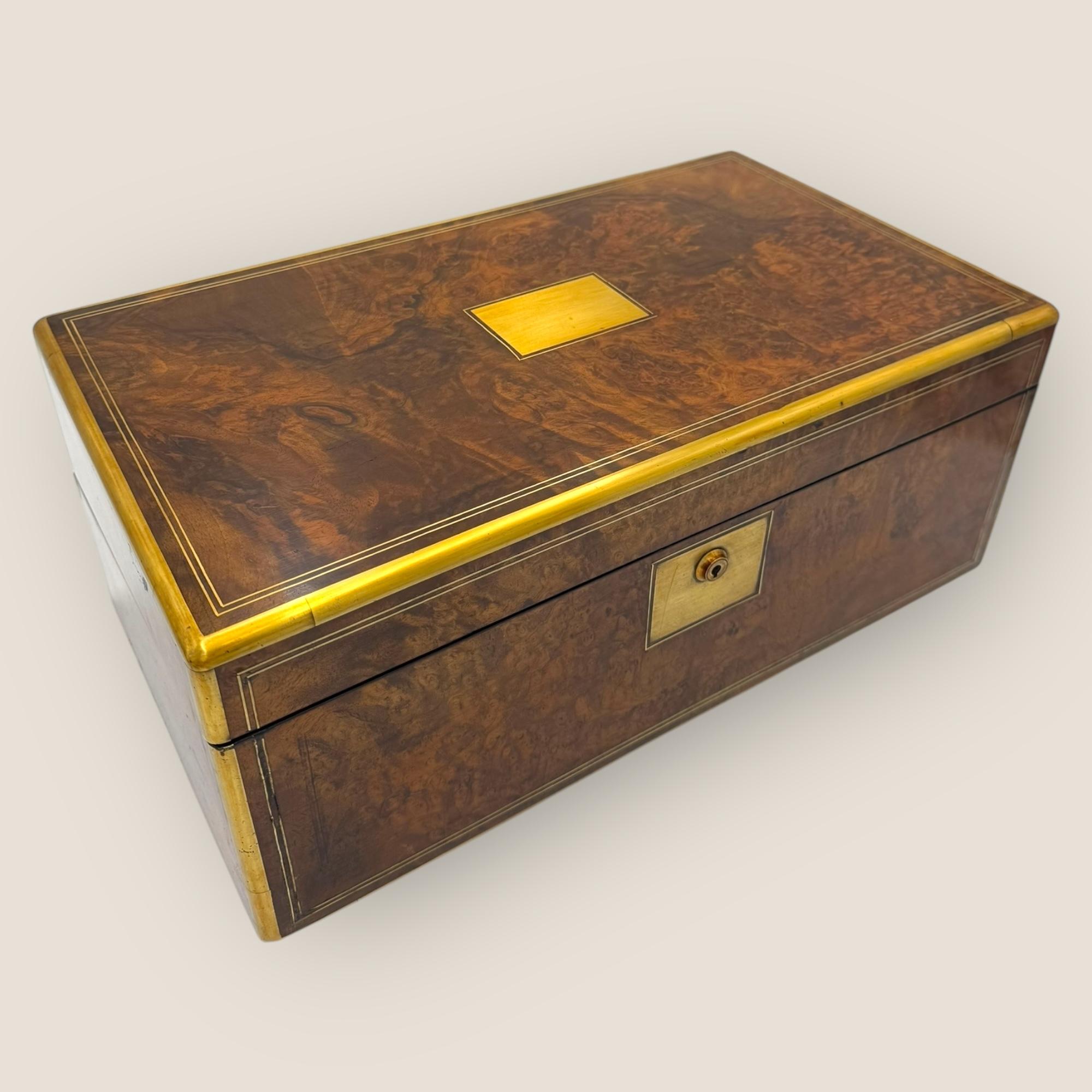 Here we have a quality Victorian (1837-1901) Burr Walnut & Brassbound Campaign Writing Slope with hidden compartments. With a beautiful burr walnut veneer to the exterior and solid mahogany interior. Each surface is inlaid with brass stringing and