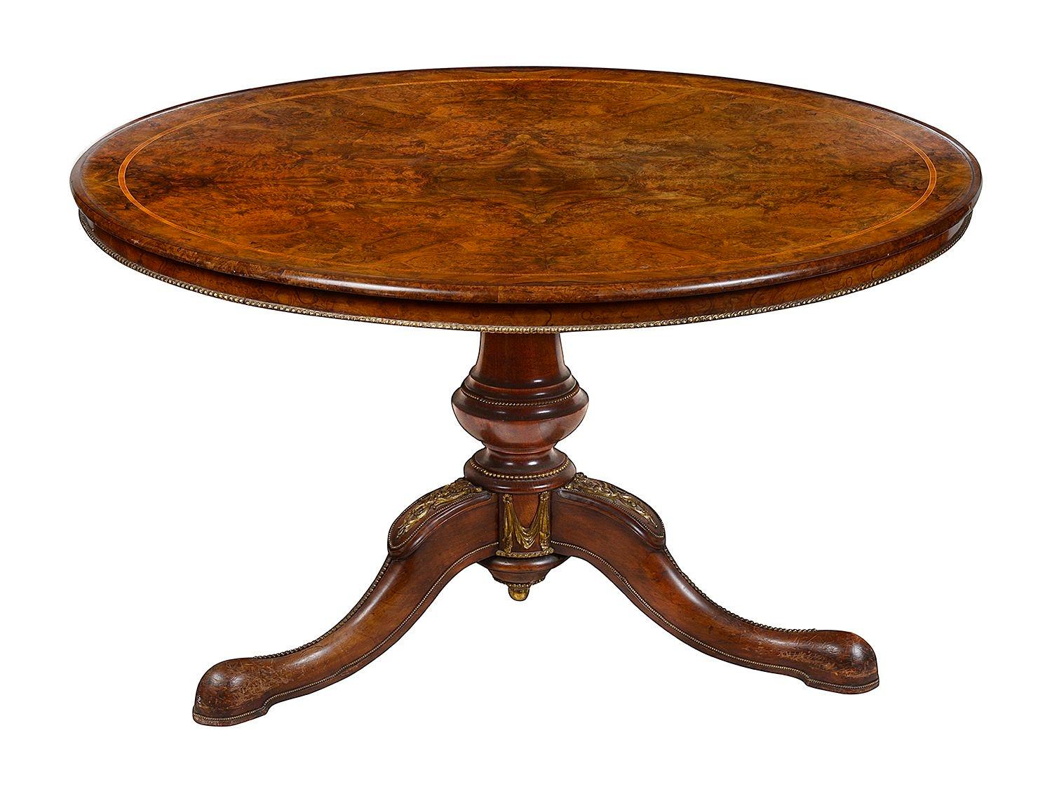 A fine quality Victorian period Burr Walnut centre table, with Tulip wood inlaid cross banding, raised on a tripod base with gilded ormolu mounts and mouldings.
In the manner of Holland and Son.
Holland and Sons Antique Furniture (1803 – 1942) were