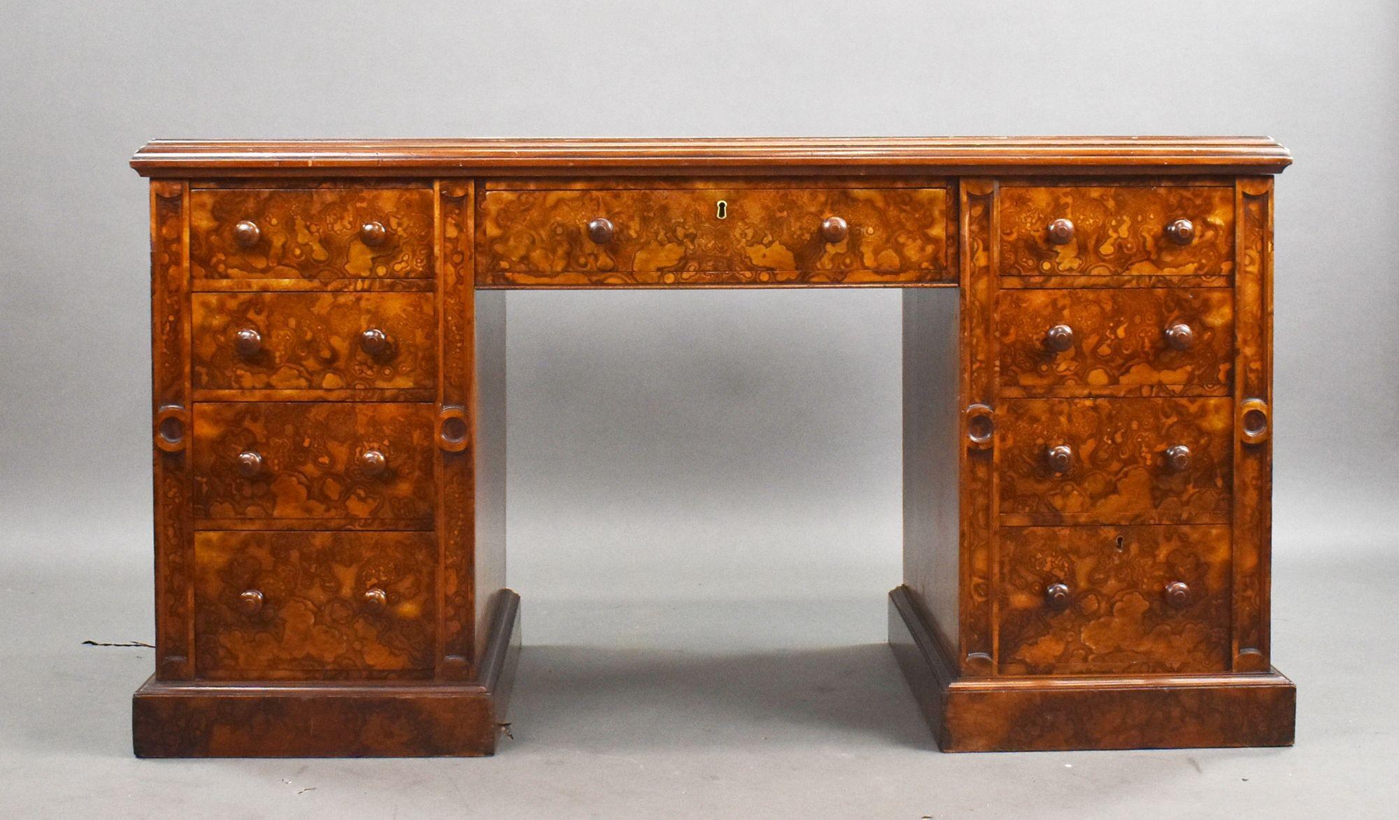 This antique Victorian burr walnut pedestal desk is a superb example of late 19th-century craftsmanship, offering timeless elegance and functional design. Made in England circa 1880, the desk features richly figured burr walnut veneers and a tooled