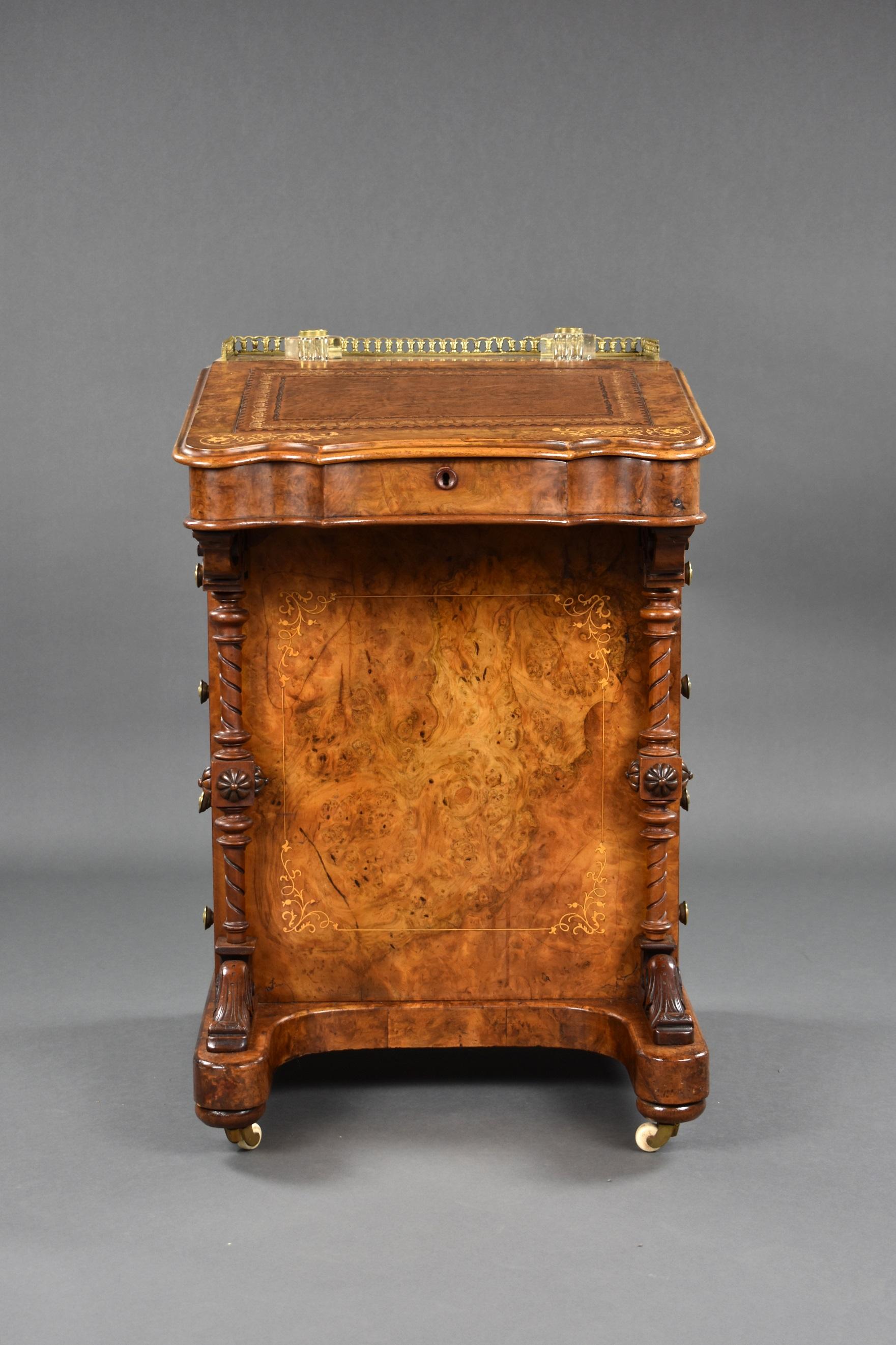 Victorian burr walnut and inlaid davenport in nice condition. It has a brass gallery to the top with an an ink well either side with decorative inlay surrounding each. The top has a tan leather insert with gold tooling to the edge, the top lifts up