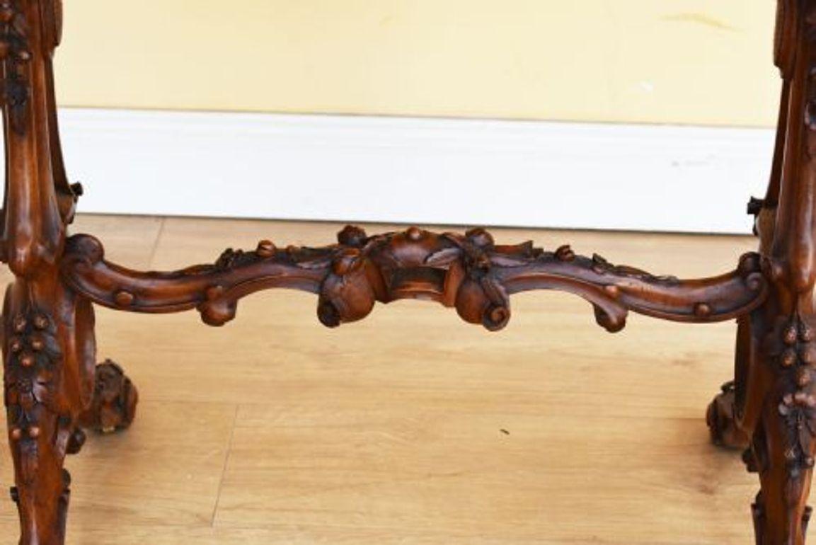 For sale is a very good quality Victorian Burr Walnut Stretcher Table with an elaborately carved base. The top of the table is inlaid and shaped, below this are two intricately carved supports with inlay, connected by a superbly carved stretcher