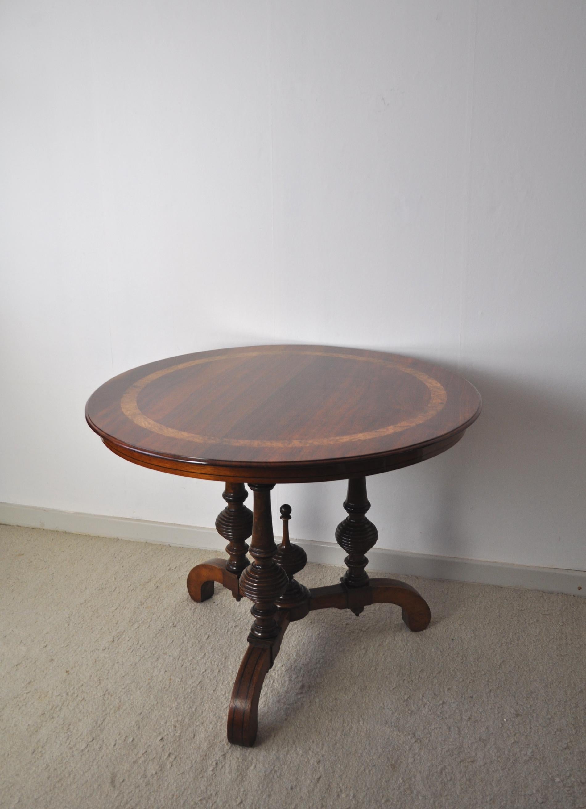 Wonderful Victorian circular mahogany centre table with beautiful band of burr walnut inlays. Ebony stringing on the side of the table. The top rests on three turned supports and three feet with ebony stringing.

The tabletop has been restored and