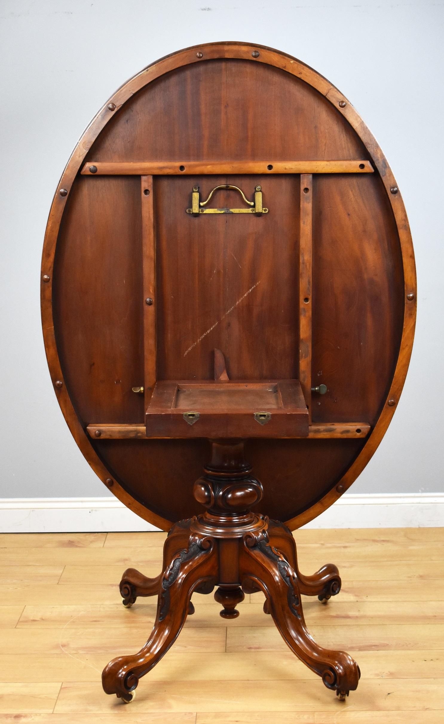 Victorian burr walnut oval tilt-top table in good condition having been recently polished by hand. The table stands on an elegant carved pedestal base on castors.