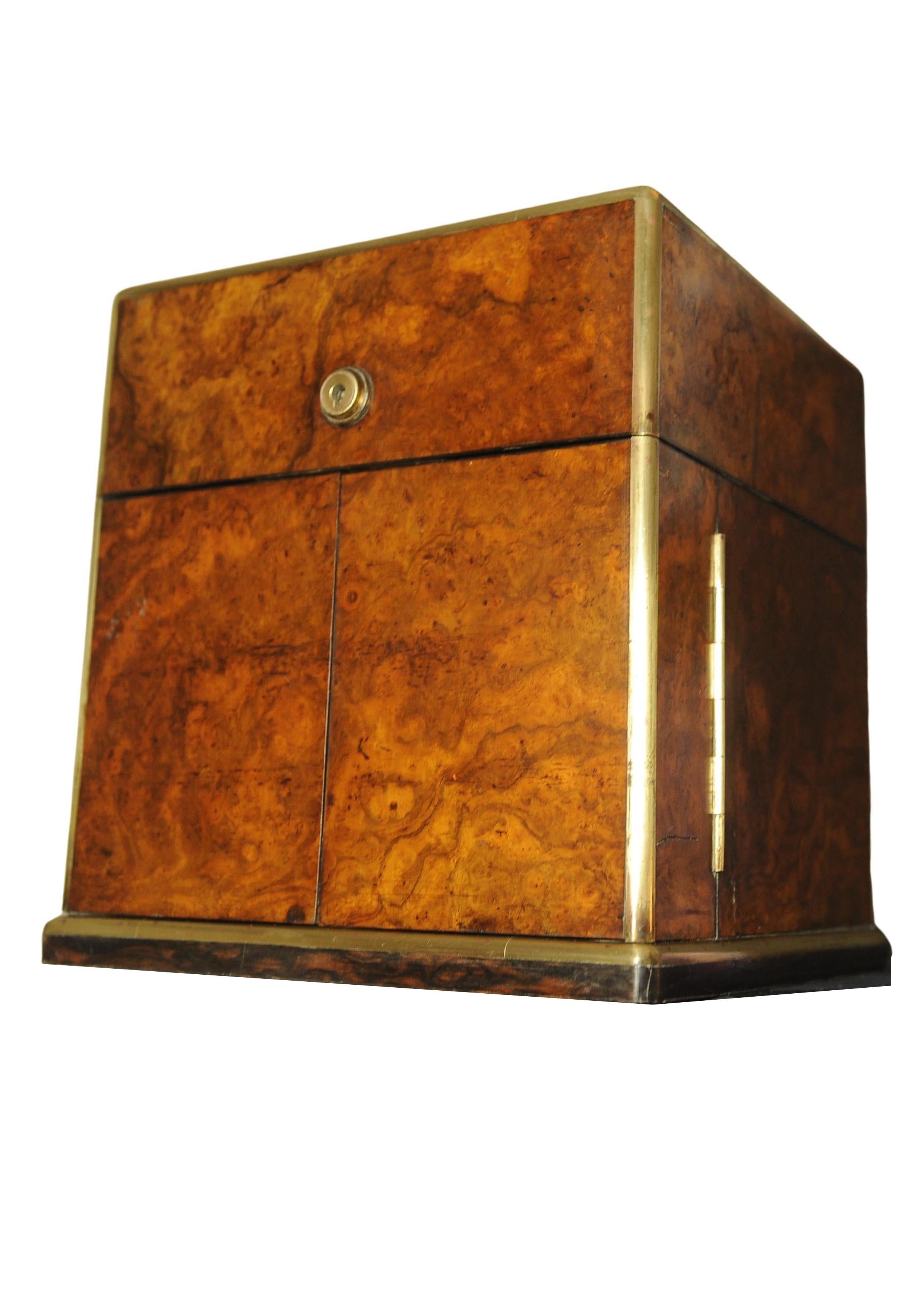 Tantalus vittoriano a due ante in radica di noce e ottone, con interno in velluto blu, pelle nera e legno satinato, con coperchio e apertura a due ante 

Con una serratura Bramah of London con una targhetta del rivenditore che recita 