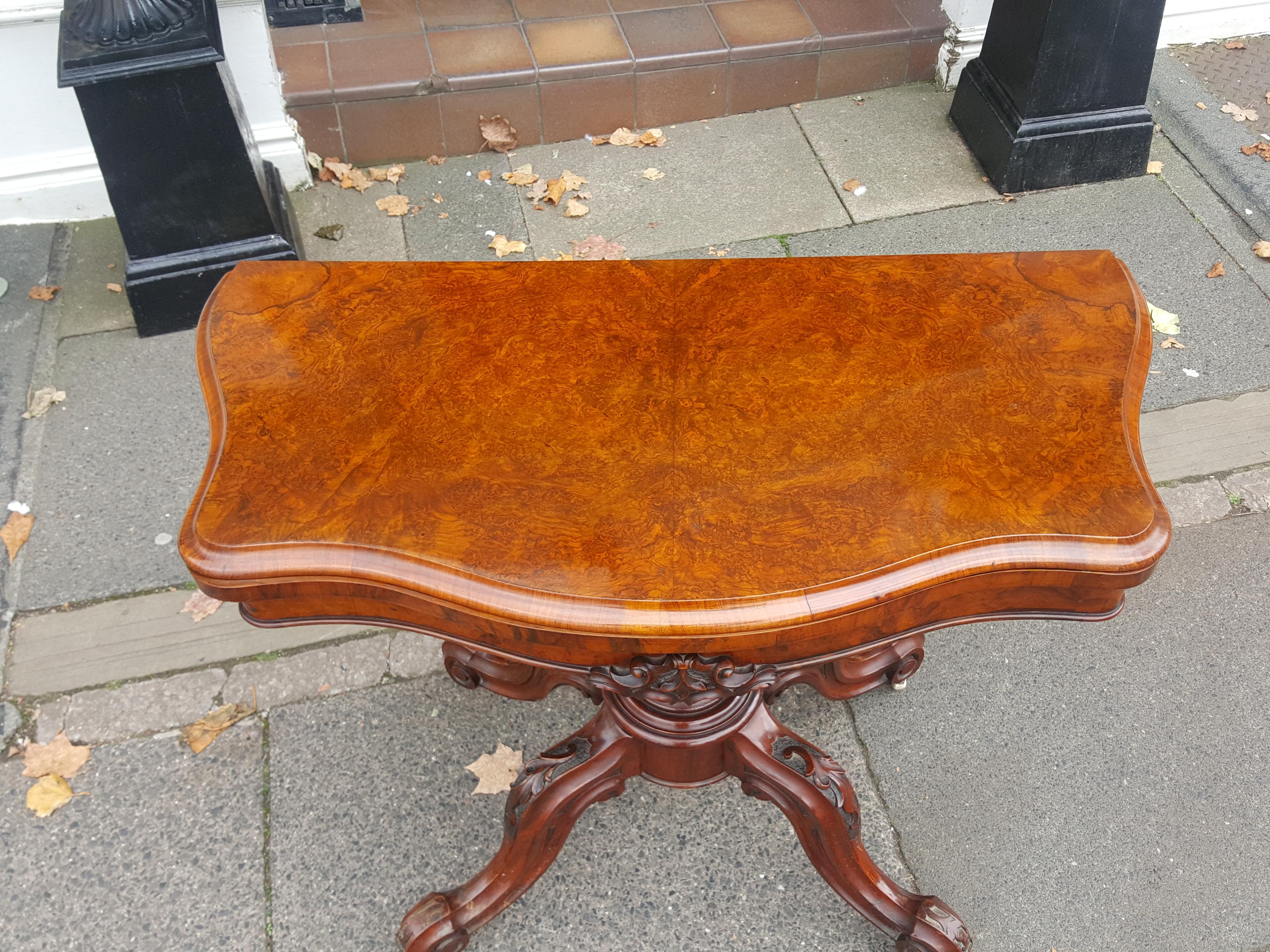 Victorian Burr walnut Serpentine card table with bookmatched veneered top, carved baluster column and scroll legs with pot castors
Measures: 36