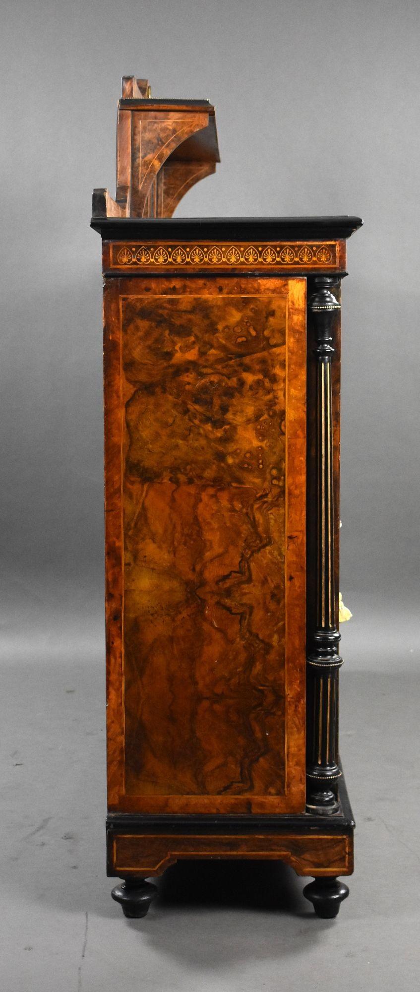 For sale is a good quality Victorian burr walnut sideboard, the top having a mirrored back, with shelves to the centre, flanked by columns and cupboards with sevres plaques, opening to ample storage space, raised on turned feet this sideboard