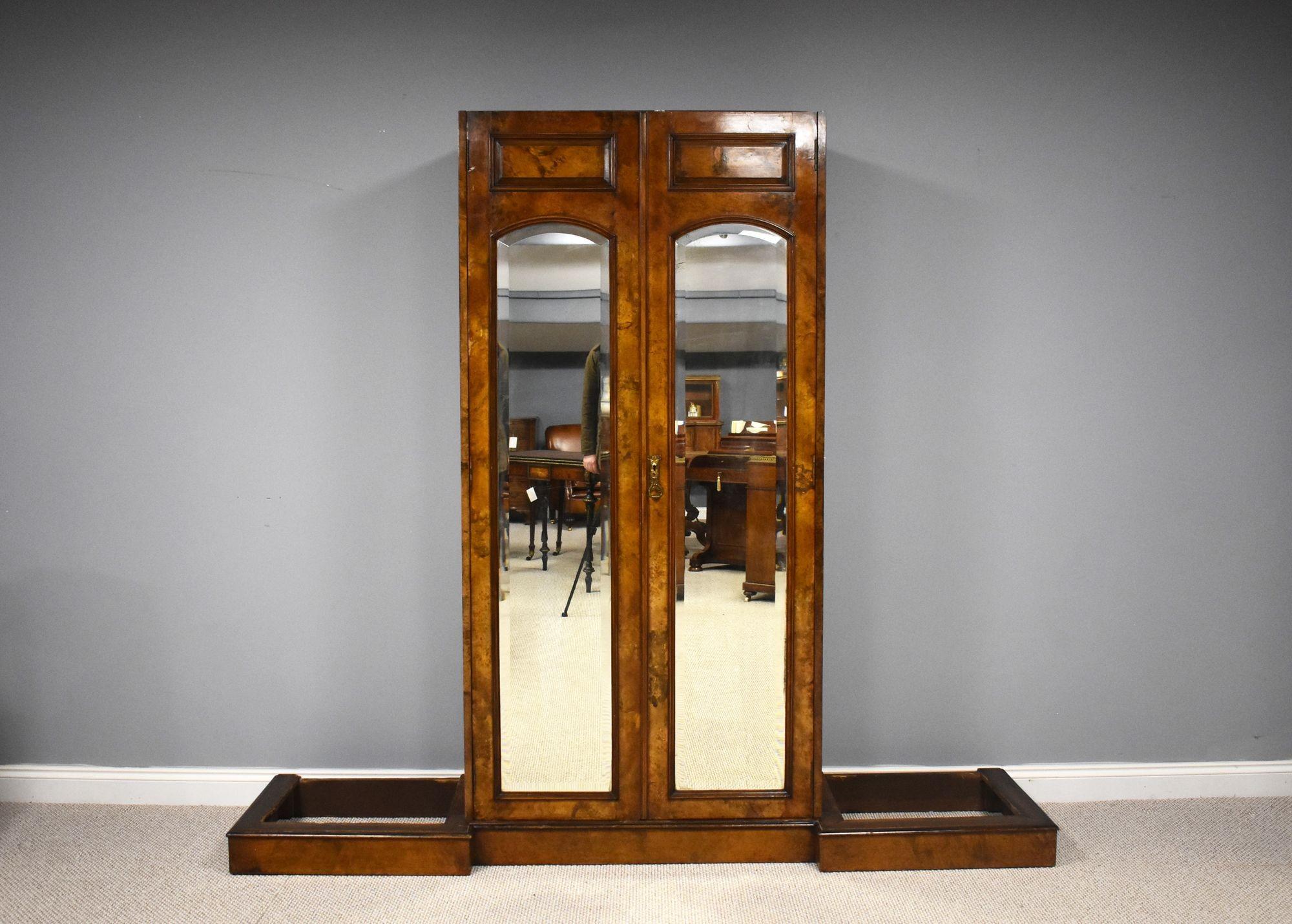 For sale is a very good quality and highly unusual Victorian burr walnut wardrobe, having a carved cornice, above two mirror doors opening to ample hanging space, flanked by glass cupboards and and burr walnut columns, above a set of four graduated