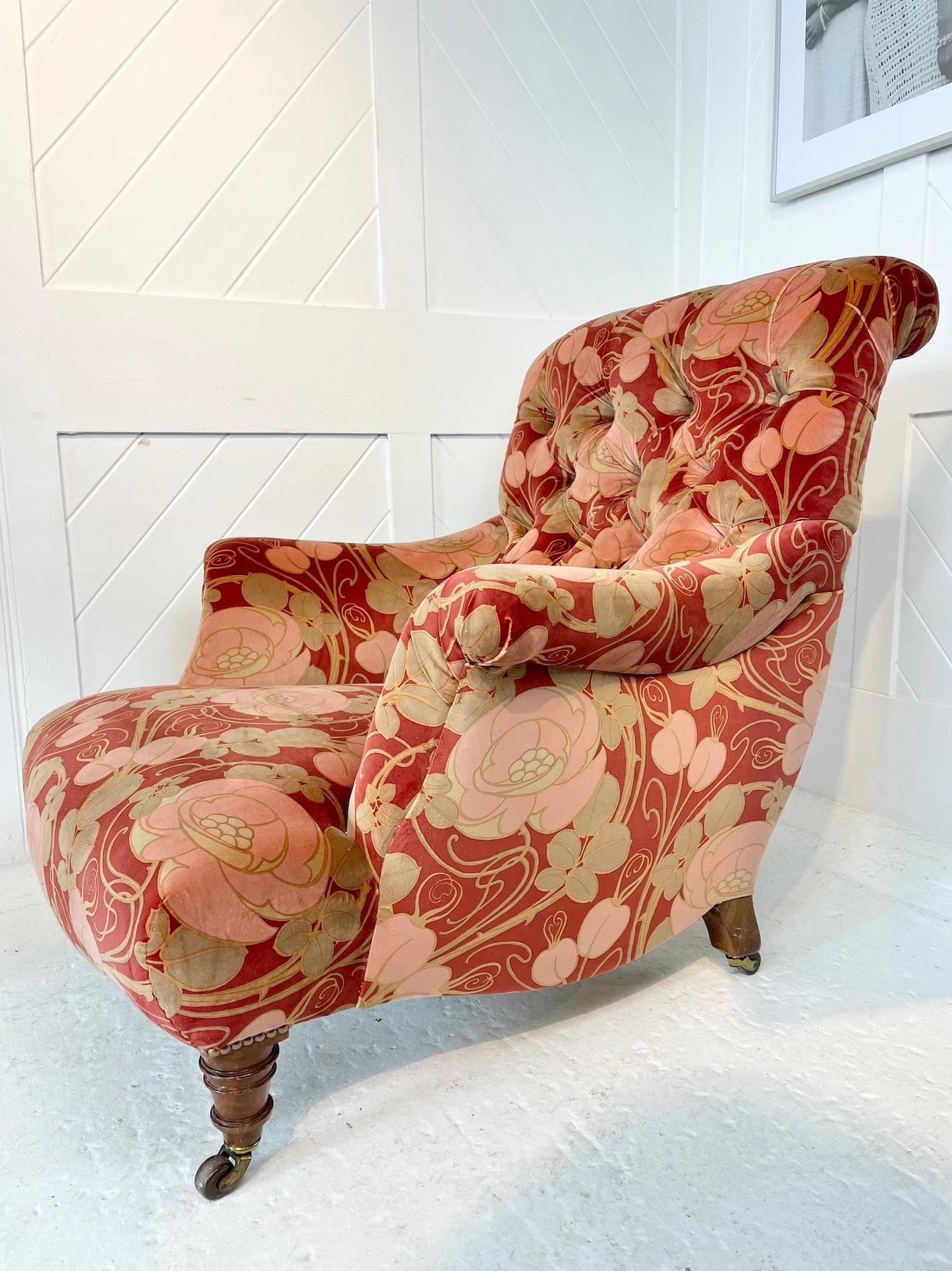 A stylish Victorian button back traditional upholstered armchair with turned walnut feet raised on brass castors, covered in cotton velvet fabric 'Glasgow Rose' by Patch Rogers Design. 