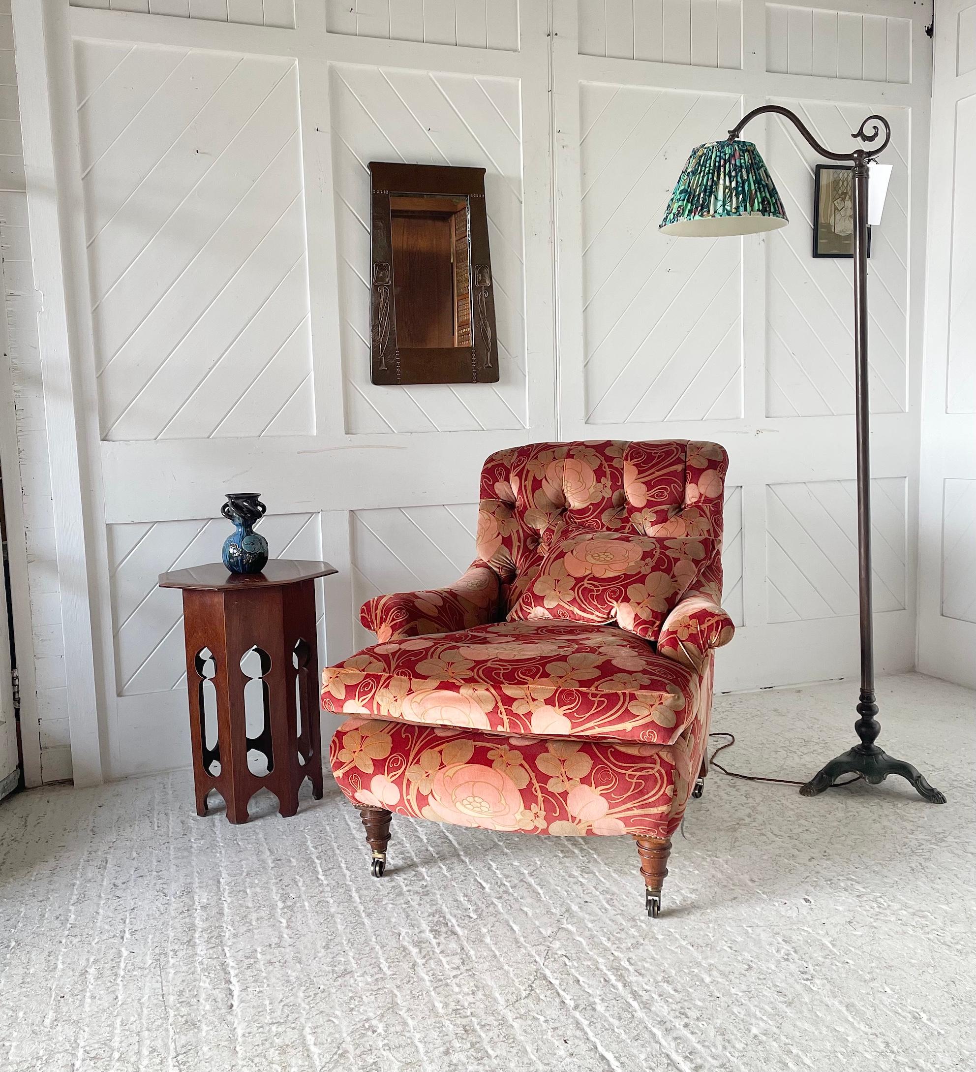 Elegante sillón victoriano tradicional tapizado con respaldo de botones y patas de nogal torneadas sobre ruedas de latón, tapizado en tela de terciopelo de algodón 