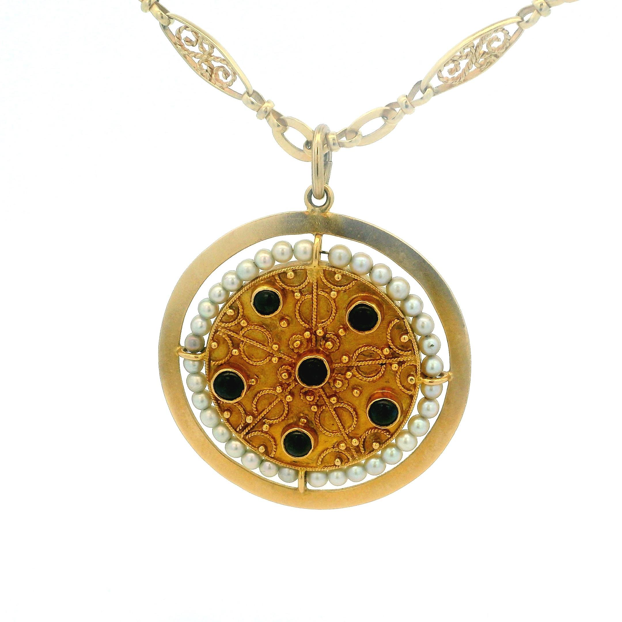 Un exquis pendentif victorien, vers 1880, réalisé en or jaune 18 carats et mettant en valeur le raffinement artistique de l'époque. Le médaillon circulaire est décoré d'un travail complexe de granulation et de filigrane, serti de six saphirs