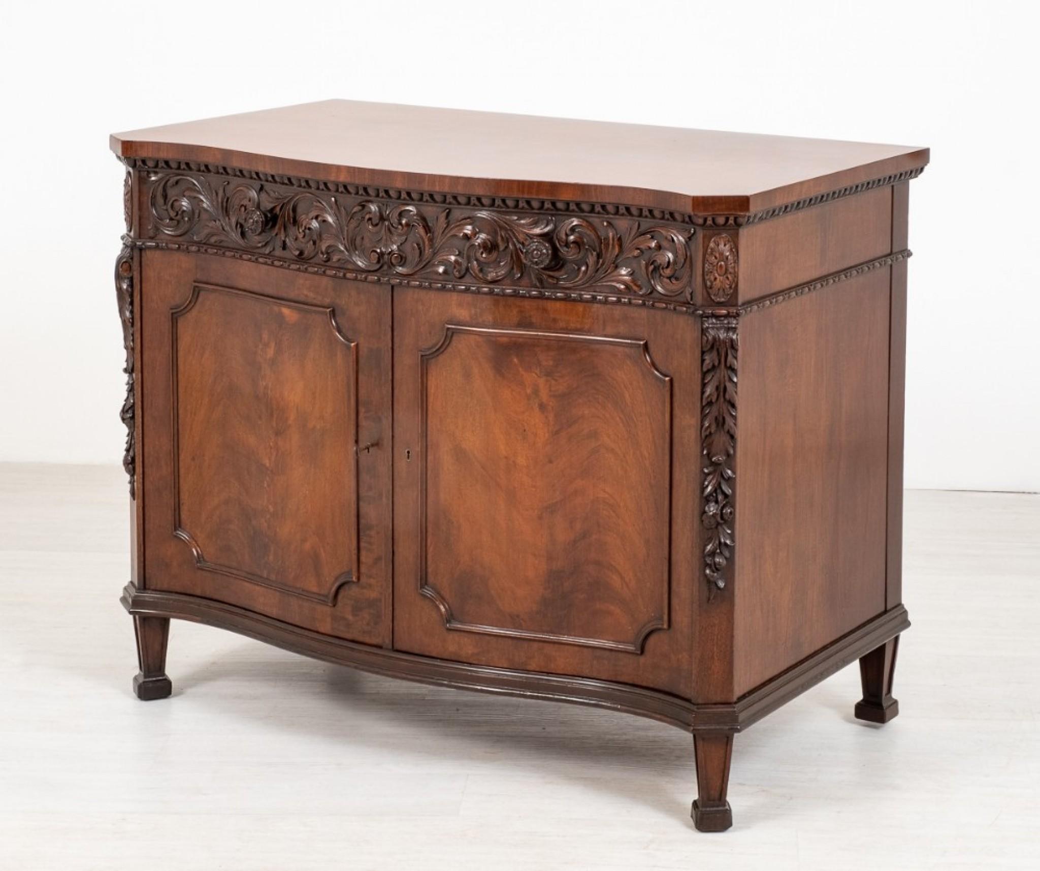 A wonderful quality mahogany 2 door side cabinet of serpentine form.
Standing Upon Tapered Legs with Block Feet.
circa 1900
Having 2 Panelled Doors Which Feature Wonderful Mahogany Timbers.
The Doors Open To Reveal a Bank of Drawers and