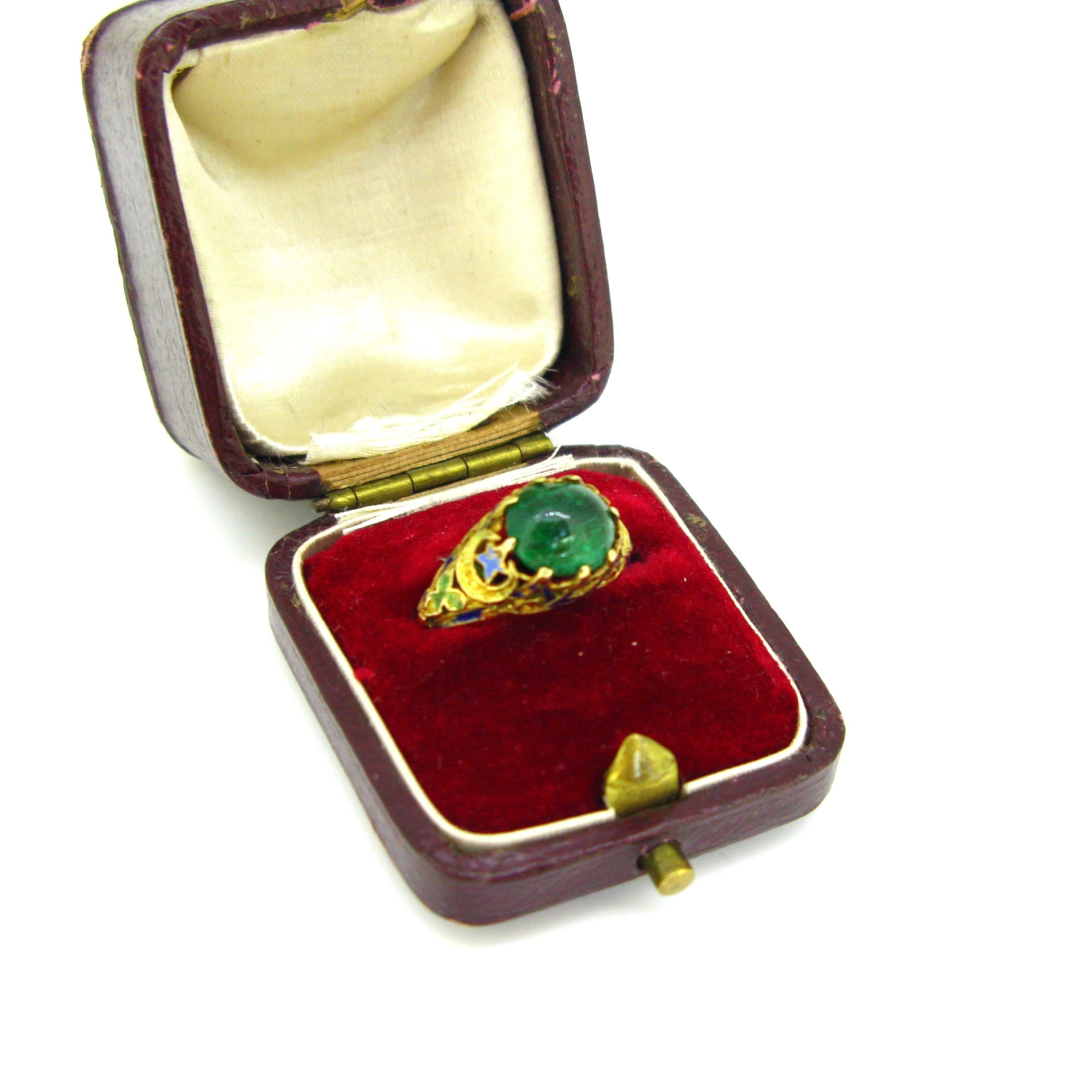 This lovely ring comes directly from the Victorian era. It is made in 14kt yellow gold. It has been adorned with enamel and set with a cabochon cut emerald weighing around 3ct. The precious stone presents few traces of wears and there are some