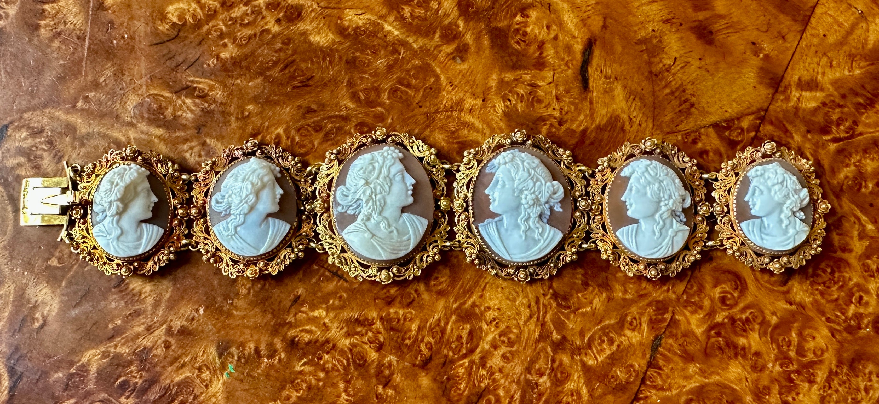Indulge in a Museum Quality Antique Cameo Bracelet in 14 Karat Gold dating to the Victorian period with six magnificent hand carved maiden woman goddess cameos of the finest quality.
Each of the six shell cameos depicts a different goddess.  The