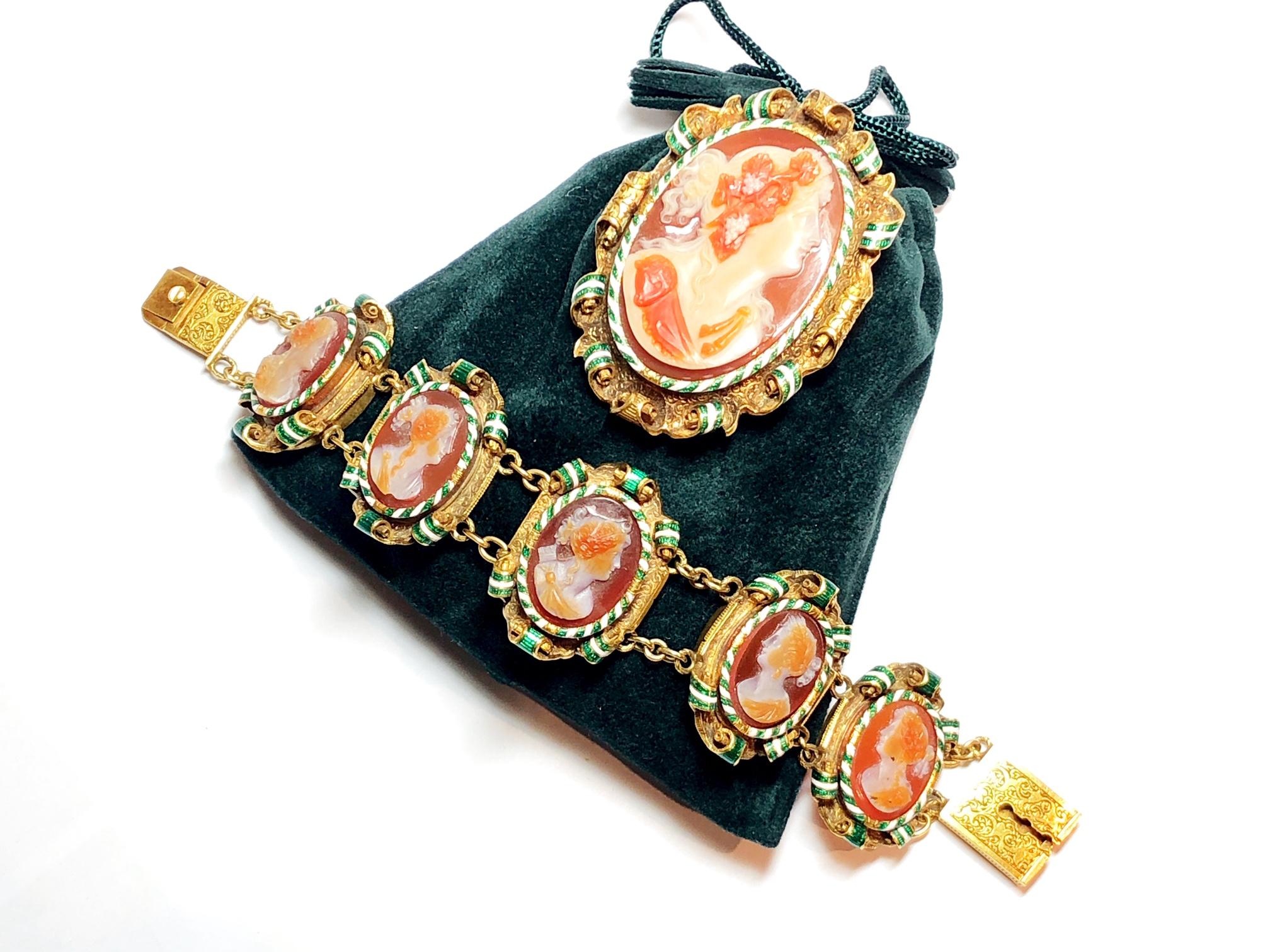 Brooch and bracelet suite, the bracelet with five cornelian coloured hard stone cameos, in gold engraved frames with scroll edges. and green and white enamel detail, with a matching brooch, brooch measures 38 x 45mm, bracelet measures 17cm 