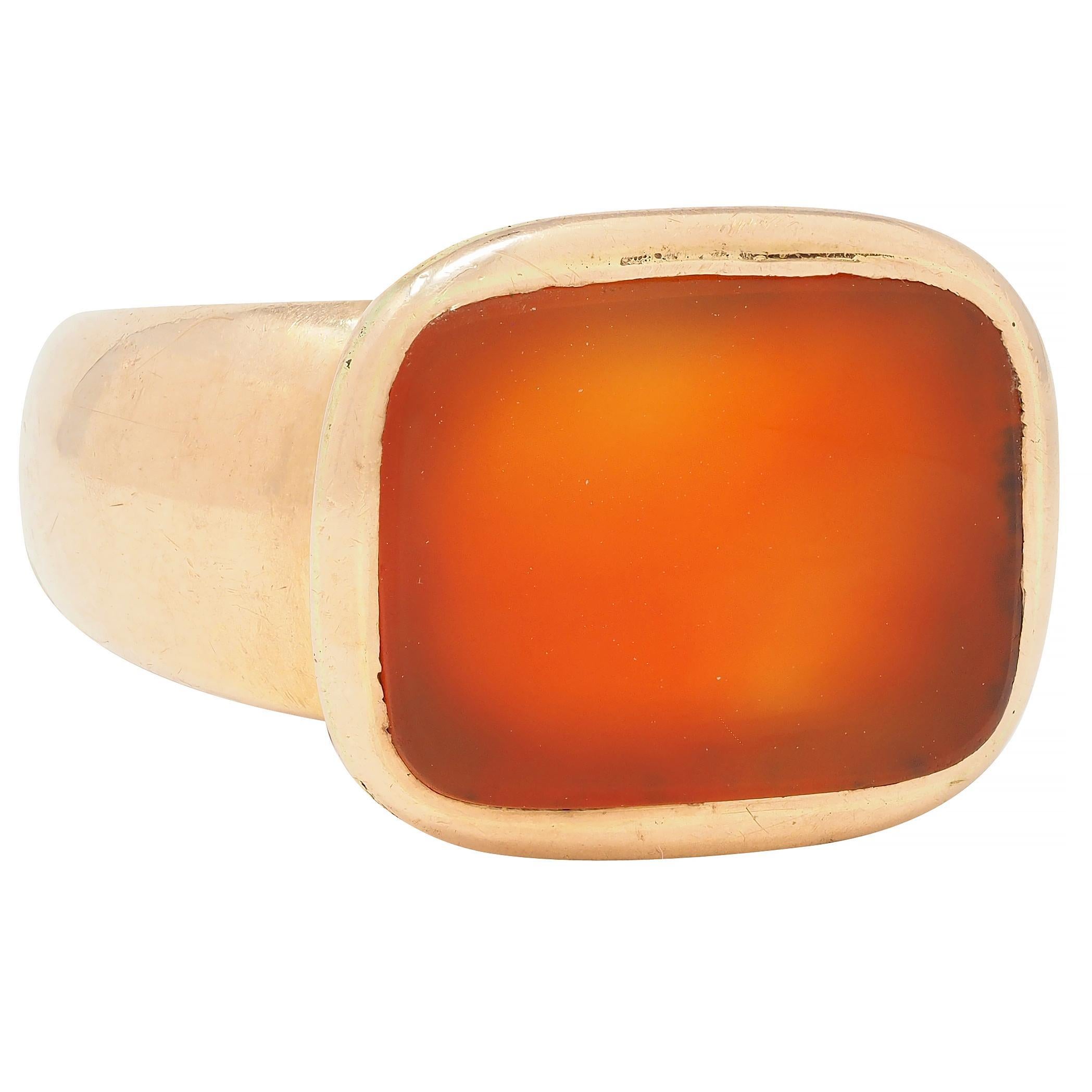 Centering a cushion-shaped carnelian tablet measuring 14.7 x 11.3 mm - translucent orangey-red
Flush set in a rose gold surround 
Completed by flared shoulders and tapered shank
Tested as 14 karat gold 
Circa: 1890s
Ring size: 8 3/4 and