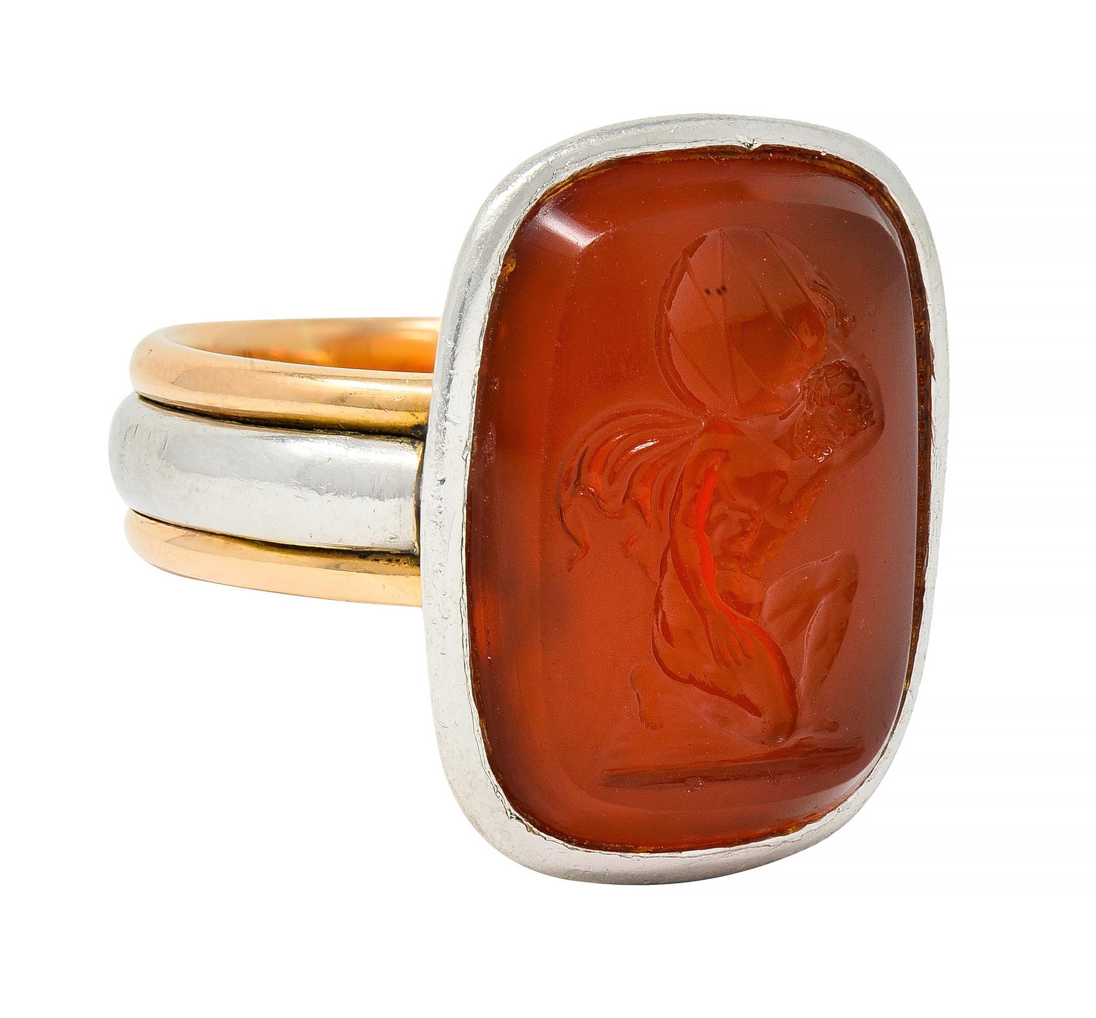 Centering a cushion-shaped carnelian tablet measuring 16.5 x 20.7 mm - translucent reddish orange 
Set in a platinum bezel surround 
Band features a rounded platinum center flanked by raised rose gold edges
Tested as platinum and 18 karat