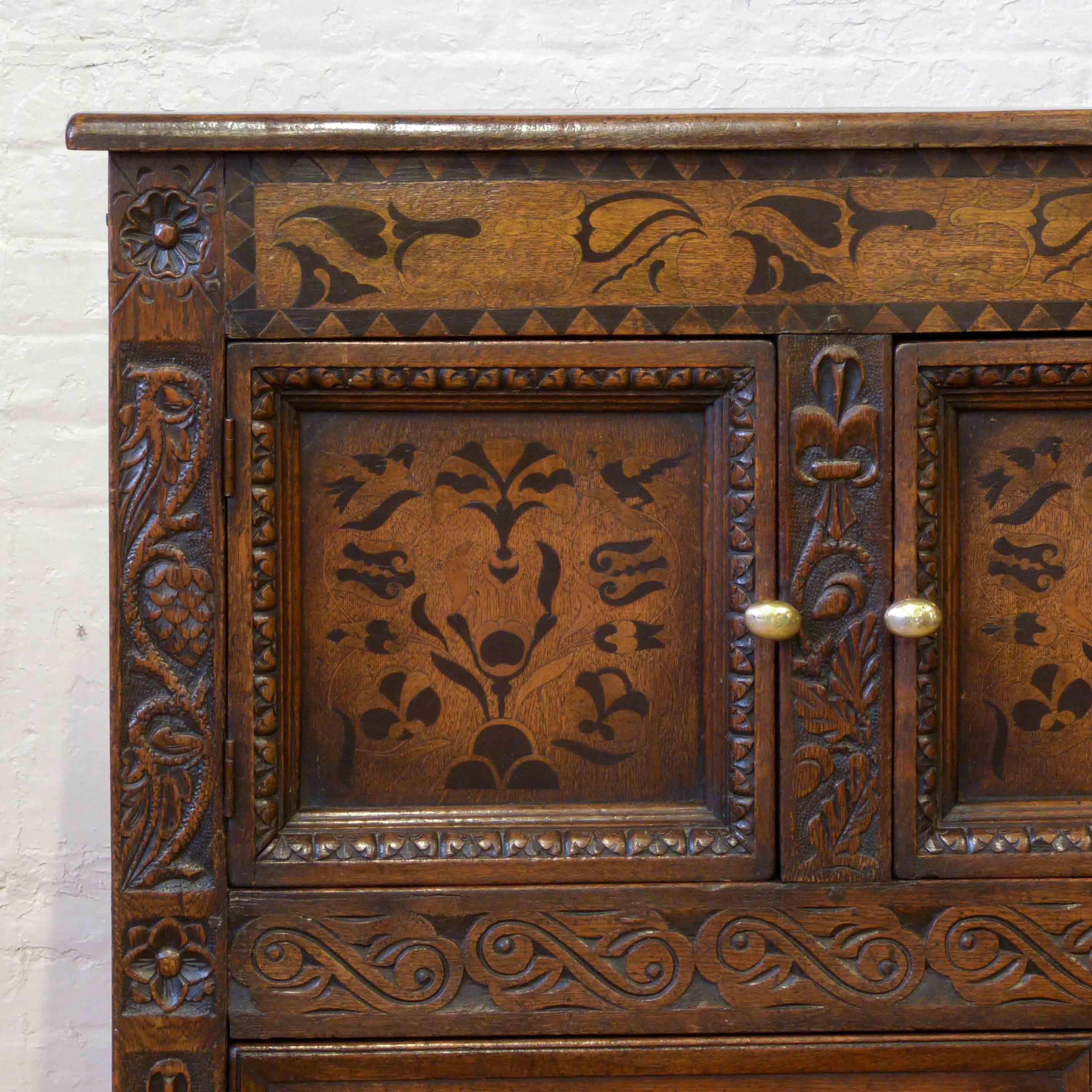 A beautiful oak cupboard of unusual proportions and useful combination of drawers and cupboards. Very much in the mid-17th century Carolean style, with attractive ebony, holly and boxwood marquetry inlays. A very solid piece that sits on baluster