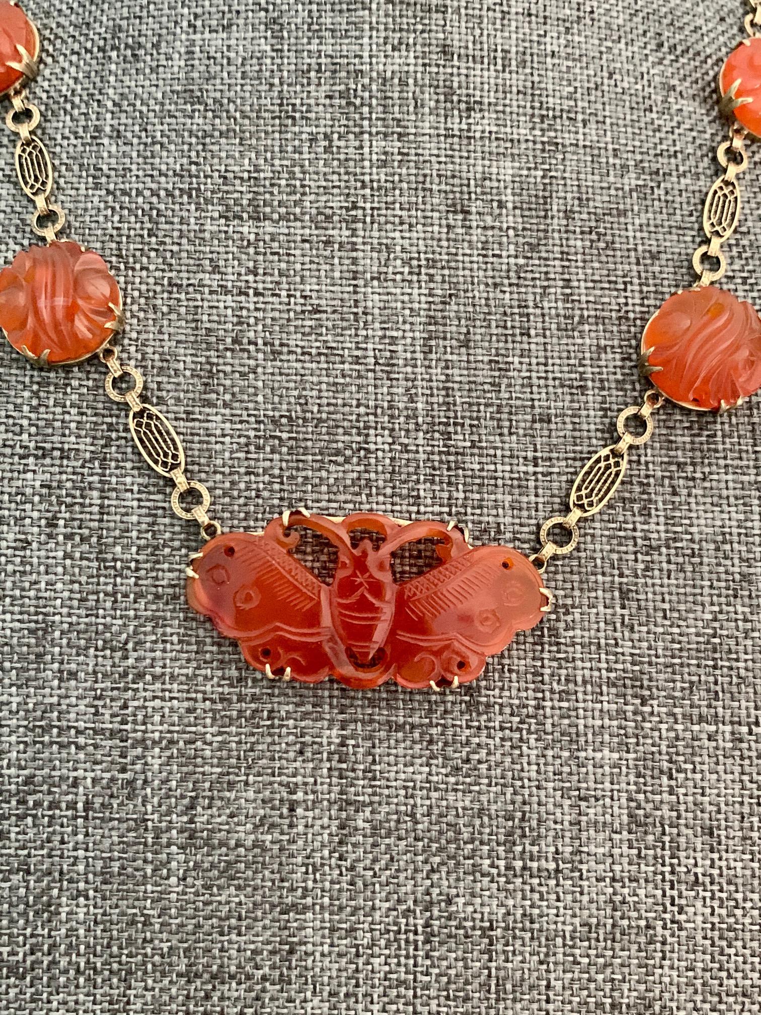 This beautiful necklace features seven carved Carnelian stones; six round stones and one beautifully carved into a butterfly.  The filigree 17
