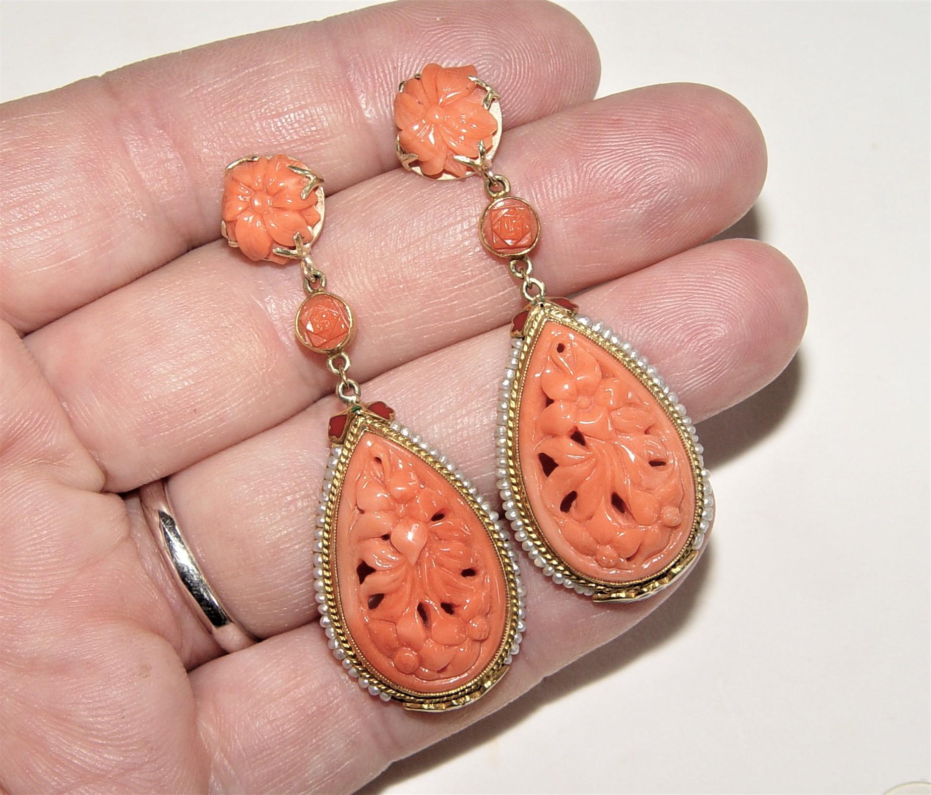 Elegant Victorian medallion style dangling earrings featuring curved coral - gorgeous floral design, surrounded with seed pearls and small enamel floral accents. The ear part of each earring contains 7mm carved coral flower with bezel set carved