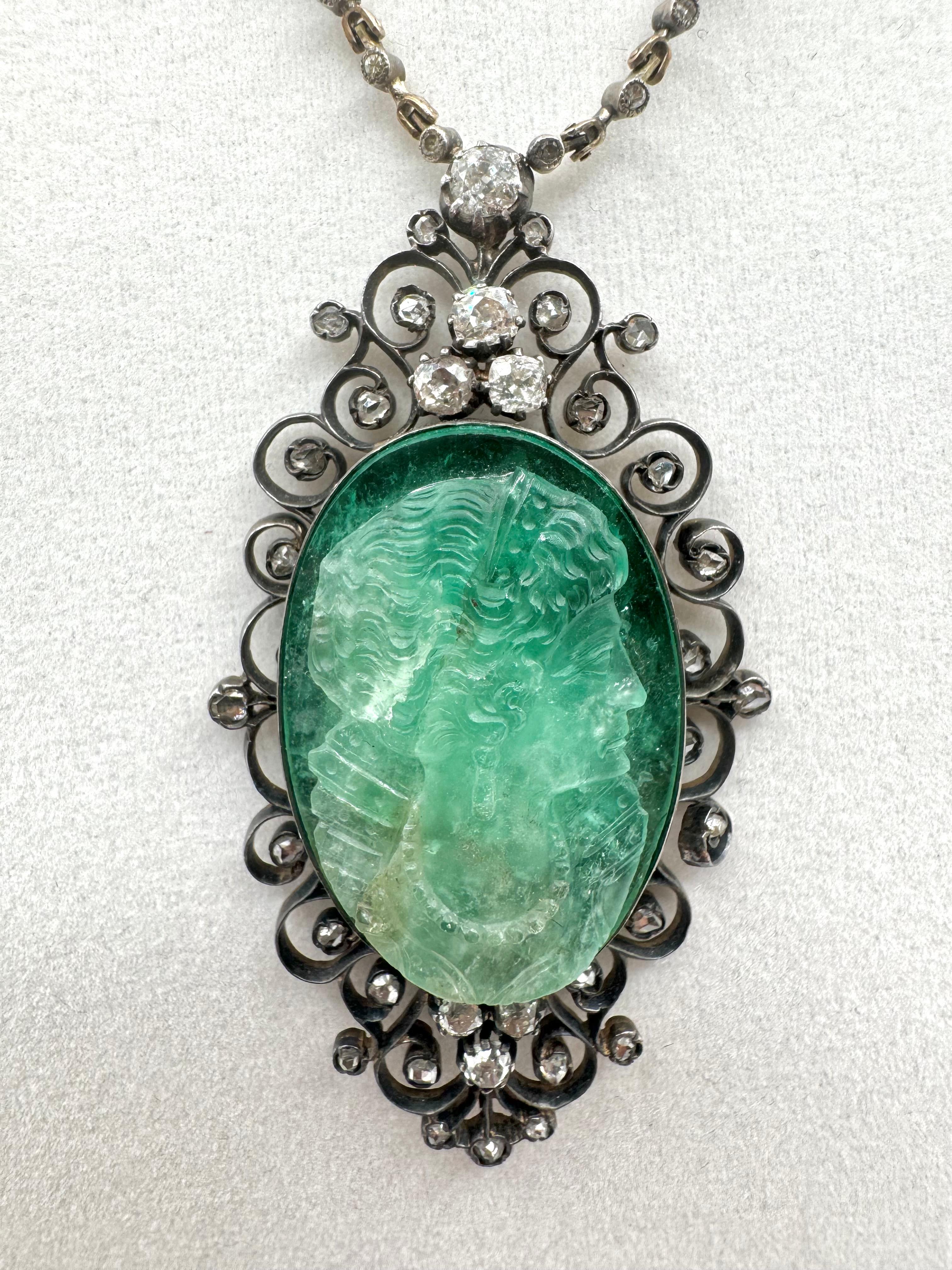 A breathtaking example of 19th-century artistry, this Victorian-era necklace features a carved Colombian emerald cameo weighing approximately 37.26 carats, intricately depicting a classical profile in vibrant green hues. The emerald is framed by an