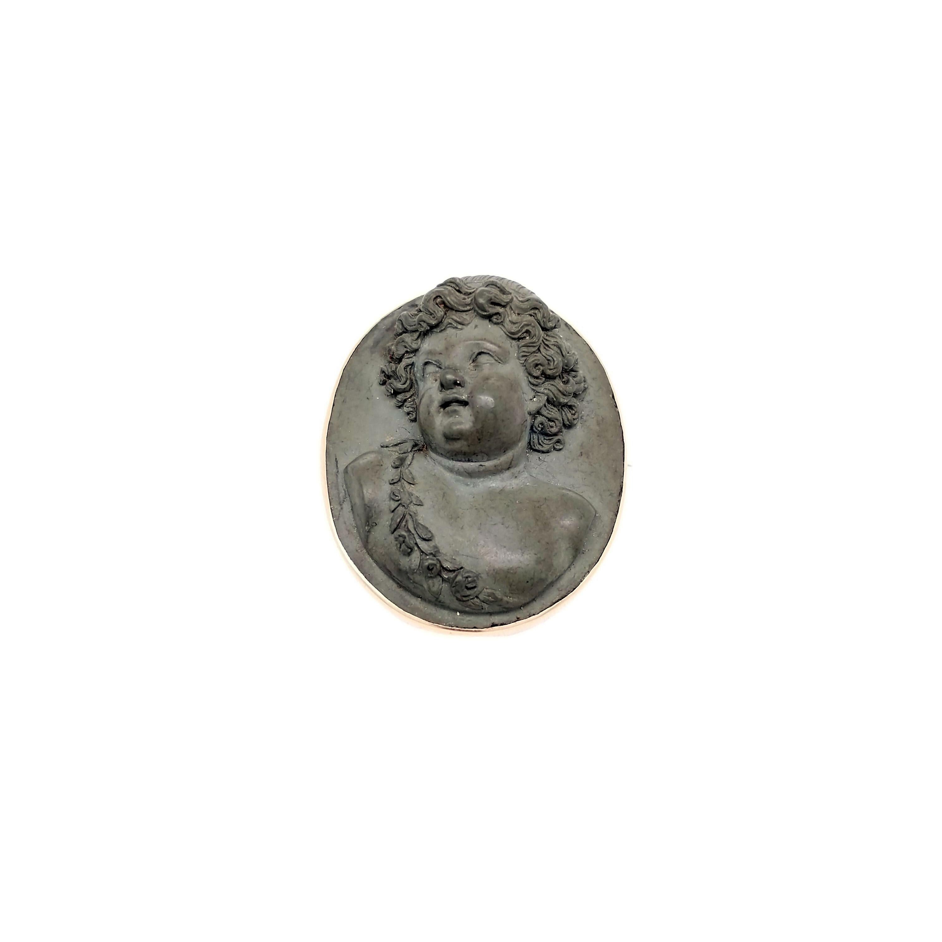 This cameo is magnificent! Made of hand-carved lava that is smooth to the touch, set in 14K yellow gold, this cameo pin will make the perfect addition to your collection! This cameo features an ornate carving of a young child with hair in curls and