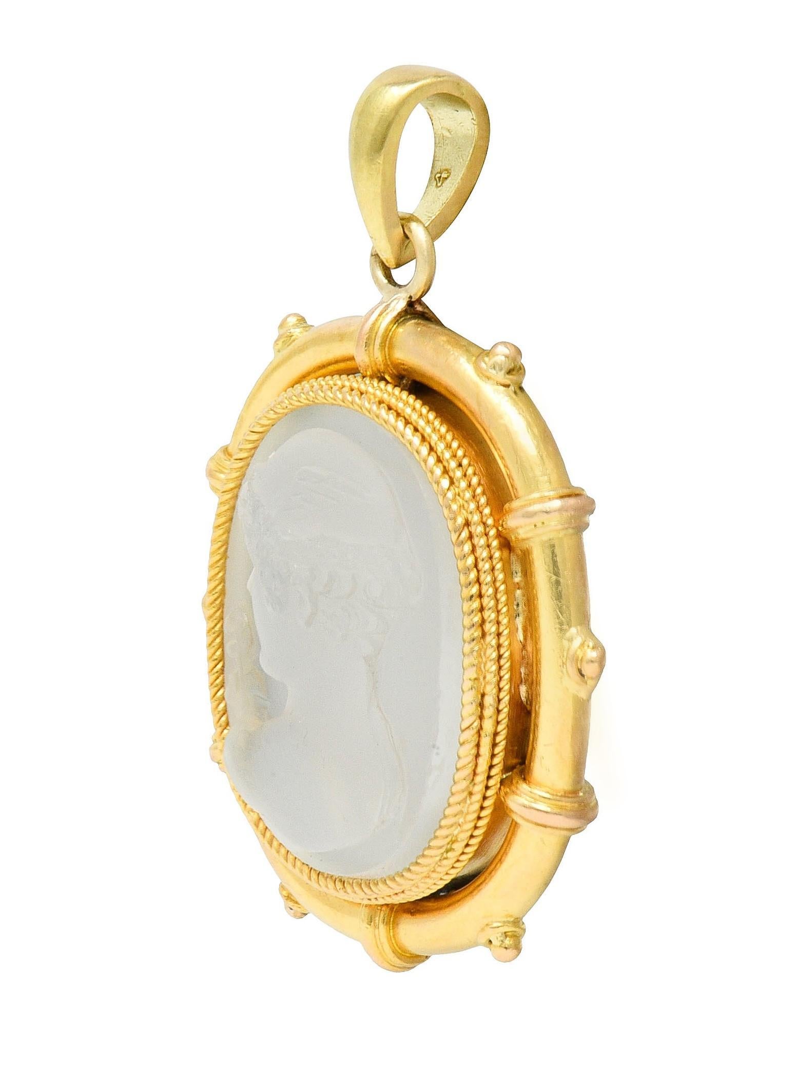 Centering a cushion-shaped moonstone tablet measuring 13.0 x 16.5 mm - carved with cameo
Depicting a cameo of the Greek god, Hermes wearing a winged helmet and with caduceus
Translucent colorless body displaying white adularescence - bezel set
With