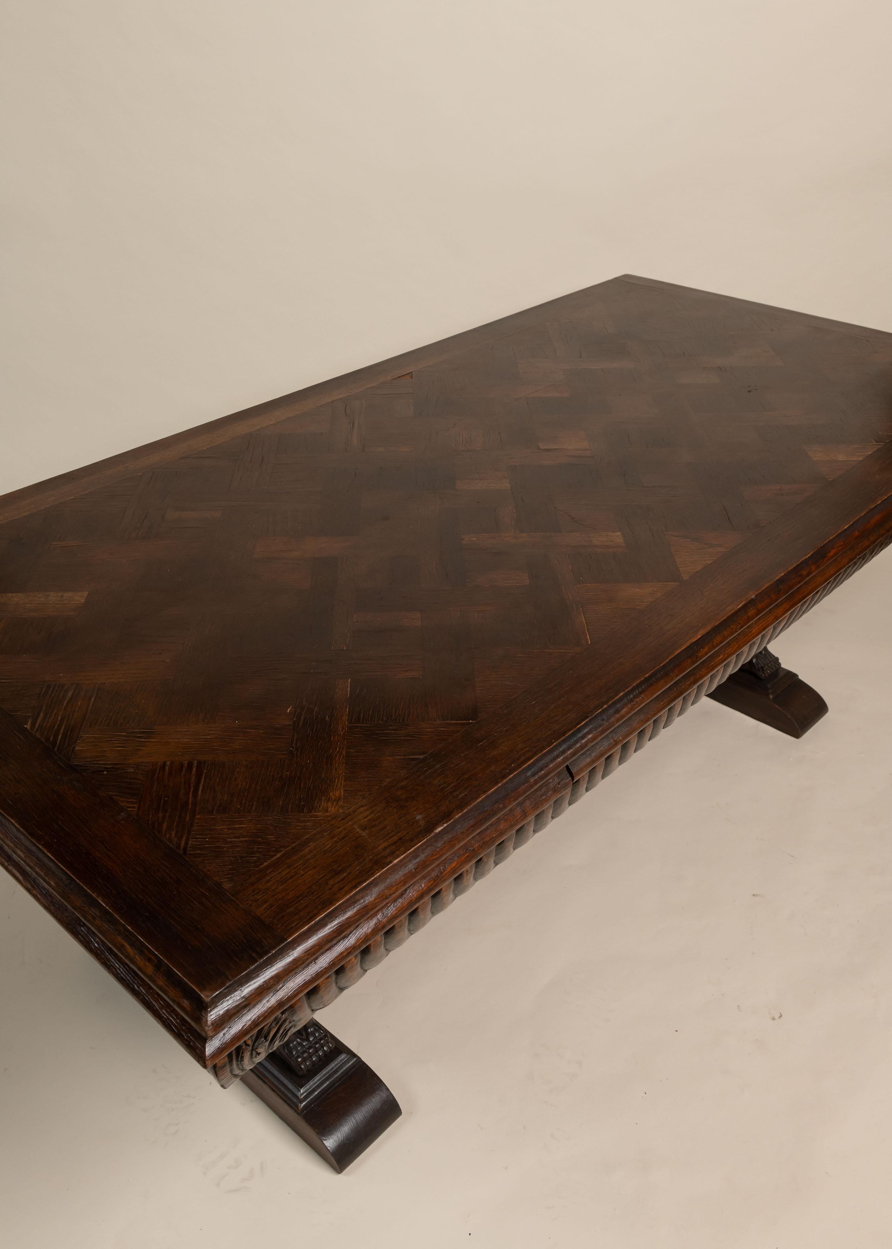 Cette table de bibliothèque en chêne de l'époque victorienne est dotée d'un plateau en parquet et d'audacieux supports de griffons sculptés. Le tablier est détaillé avec des garnitures sculptées à la main, ce qui ajoute de la texture et de la