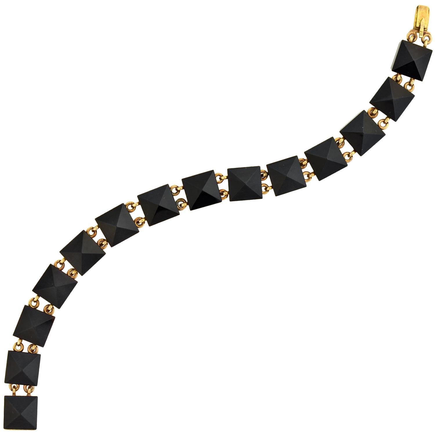 A simply stunning onyx link bracelet from the Victorian (ca1880) era! Crafted in 14kt rosy yellow gold, this gorgeous piece is comprised of 14 hand-carved onyx links which are connected together to form a flexible design. Each stone is square in