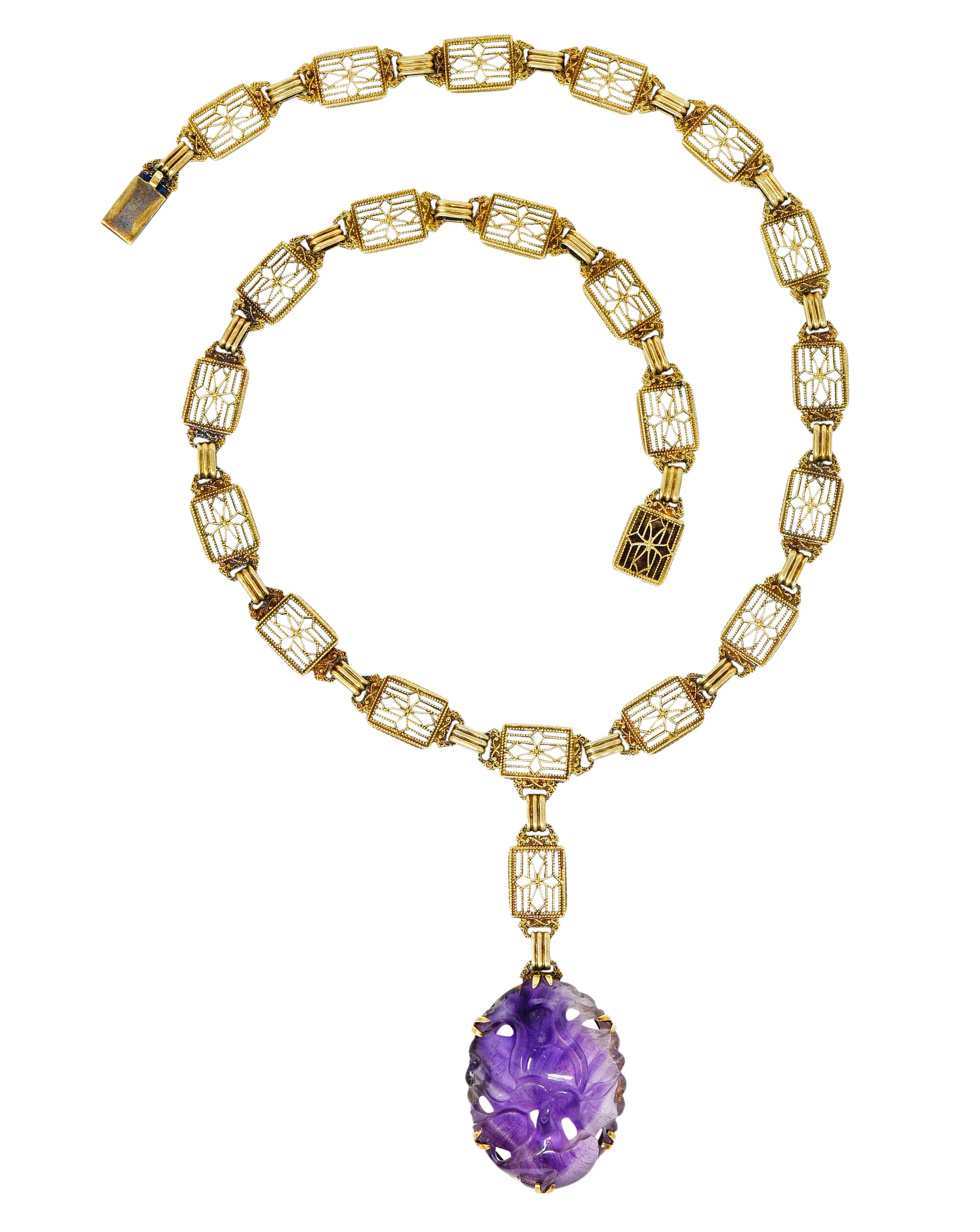 Necklace is comprised of rectangular links, pierced and with milgrain detail

Suspending a large oval drop of rutilated amethyst, deeply carved as a stylized flower

Amethyst is translucent with distinct clear to purple color zoning and features red