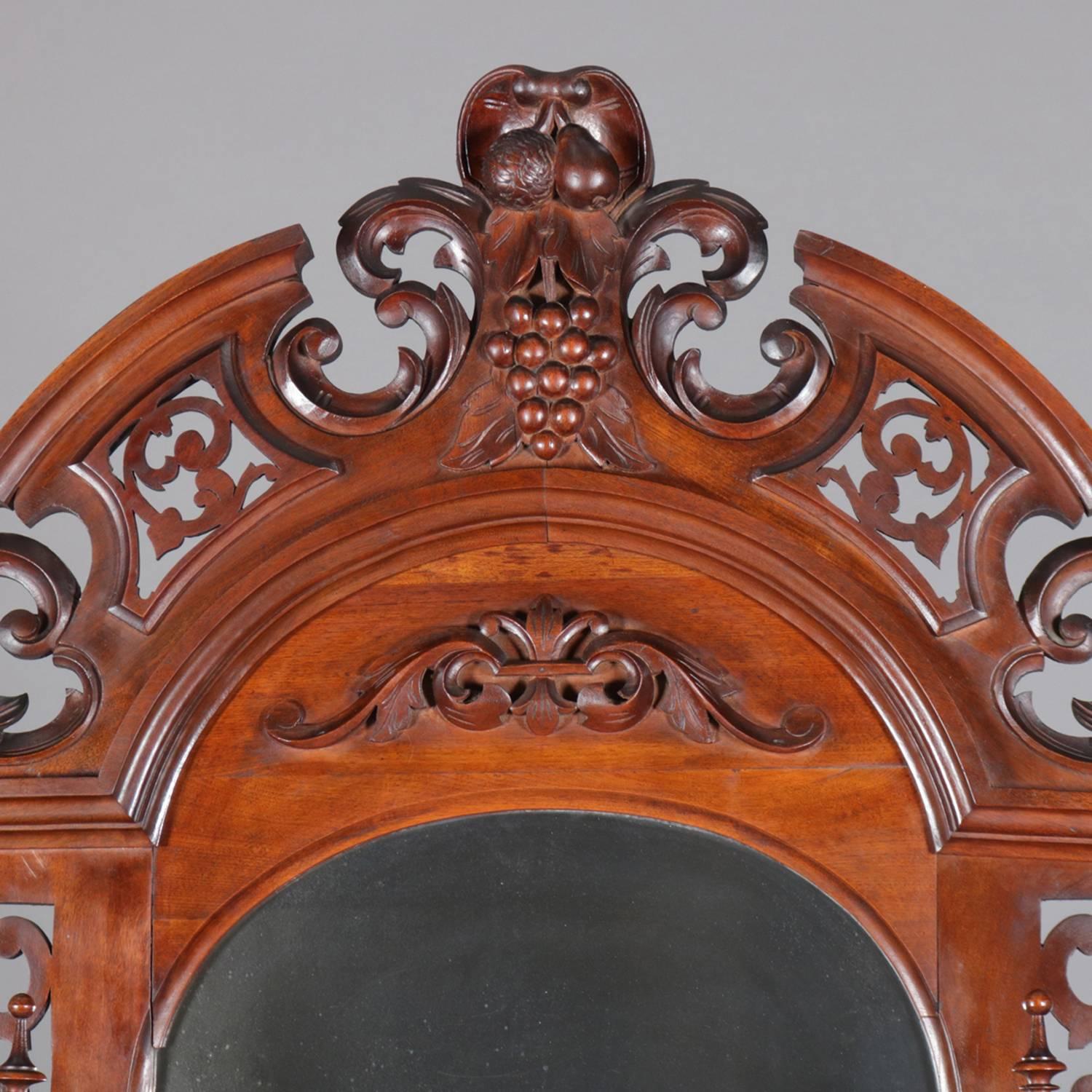 Victorian carved walnut étagère hall pier mirror feature carved walnut frame with pierced foliate and scroll broken arch crest with central fruit carved cartouche, graduated side display shelves and marble platform above single drawer, 19th