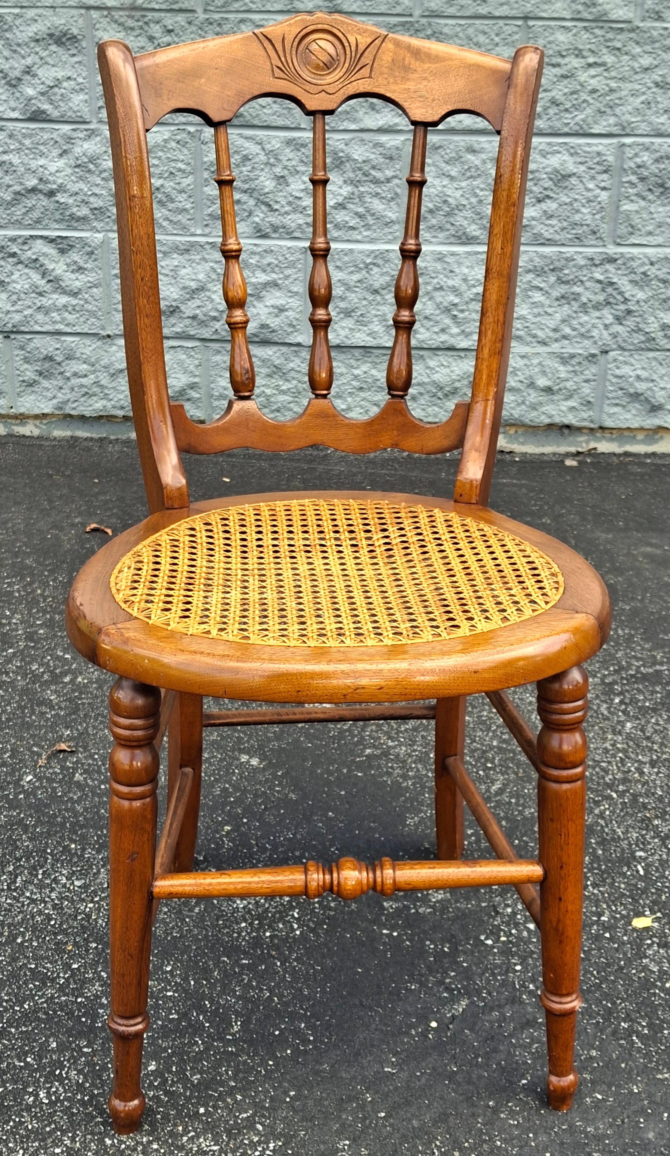A Victorian Carved Walnut and Cane Seat Side Chair. Measures 17