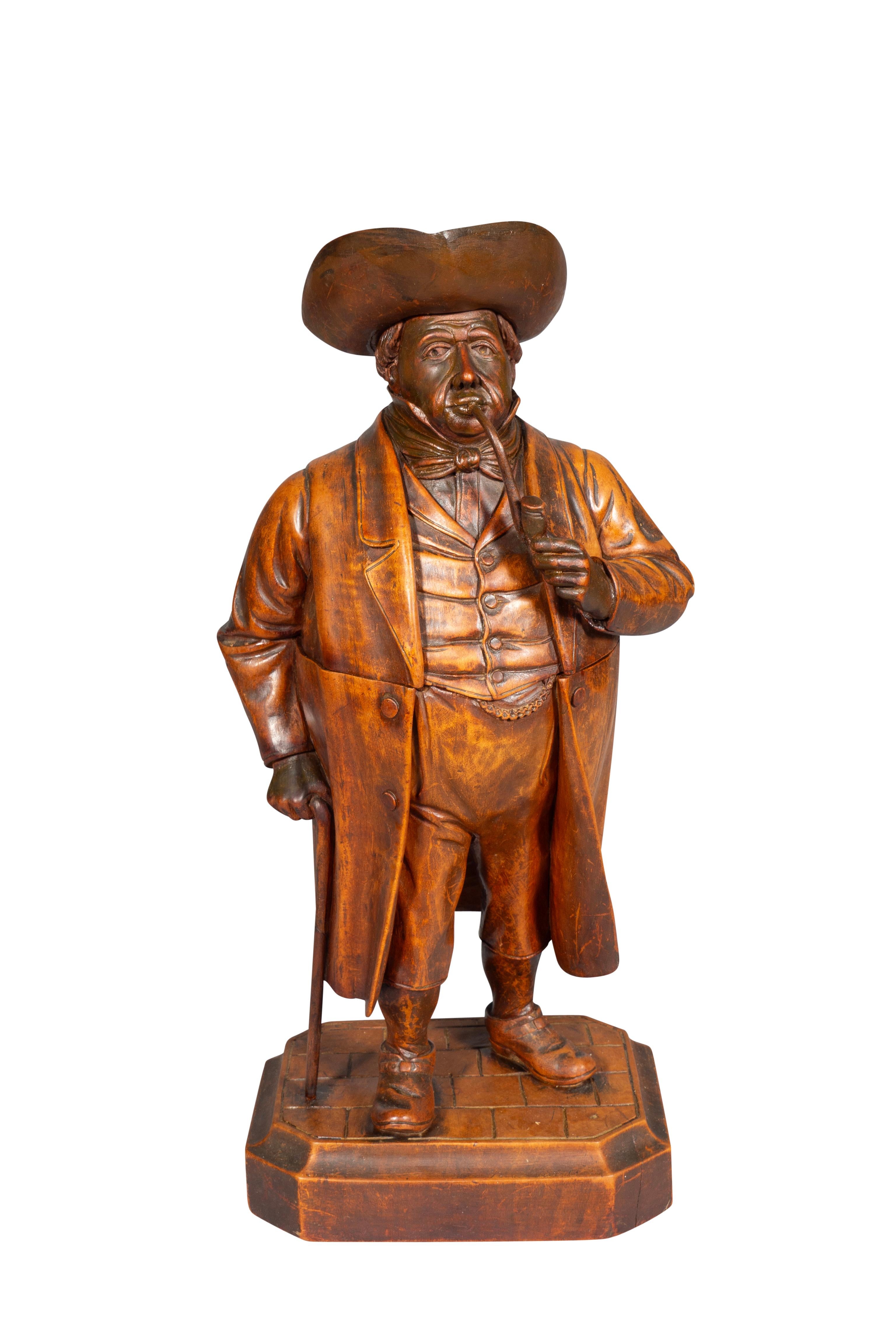 Standing figure of a gentleman wearing a hat, holding a pipe and holding a cane by his side.Hinged and opening to a humidor. Rectangular base. From an Amherst Mass estate.