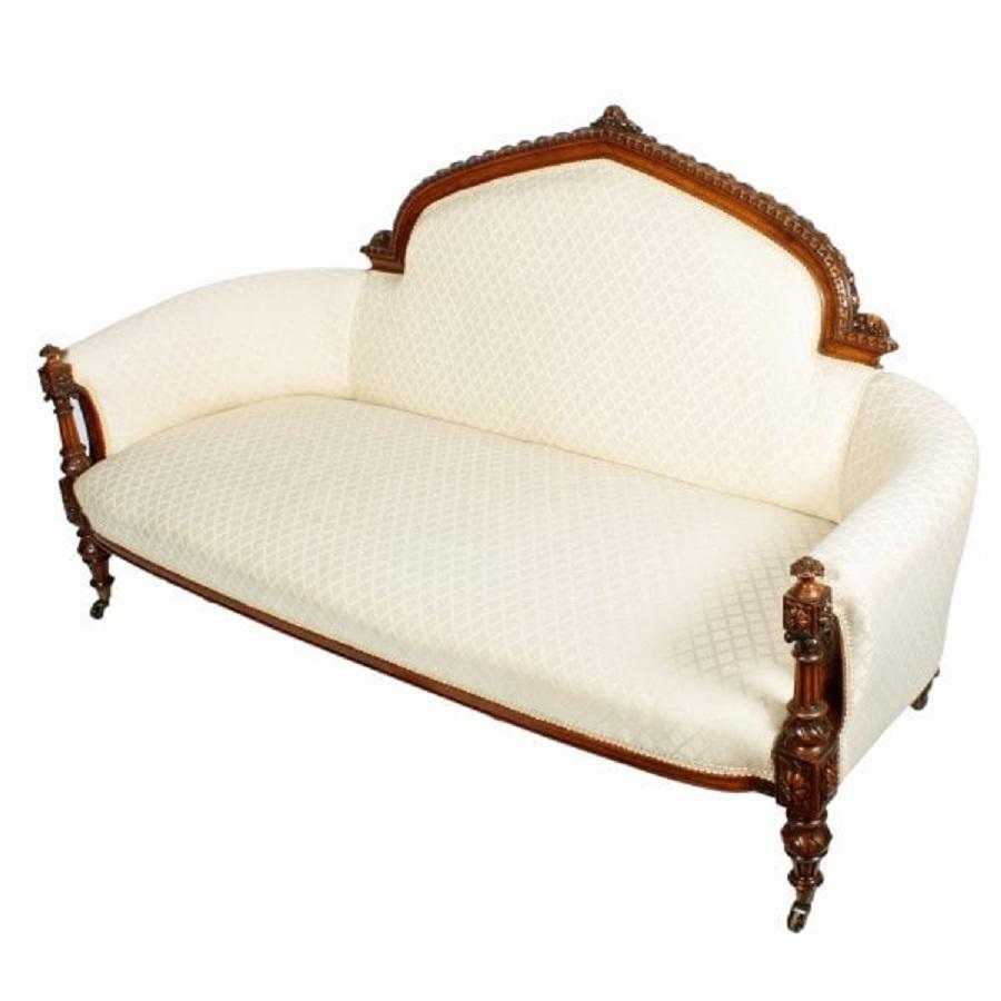 A mid 19th century Victorian carved walnut settee.

The settee has a domed back with a highly decorative carved walnut frame and is upholstered in a cream coloured contemporary material.

The front legs are turned and fluted and continue up the